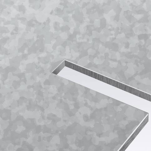 Nahaufnahme einer grauen, strukturierten Metalloberfläche mit einem rechteckigen, vertieften Bereich.