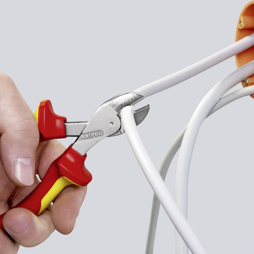 Eine Hand hält eine rote Zange und schneidet ein weißes Kabel, das aus einer orangefarbenen Steckdose kommt.