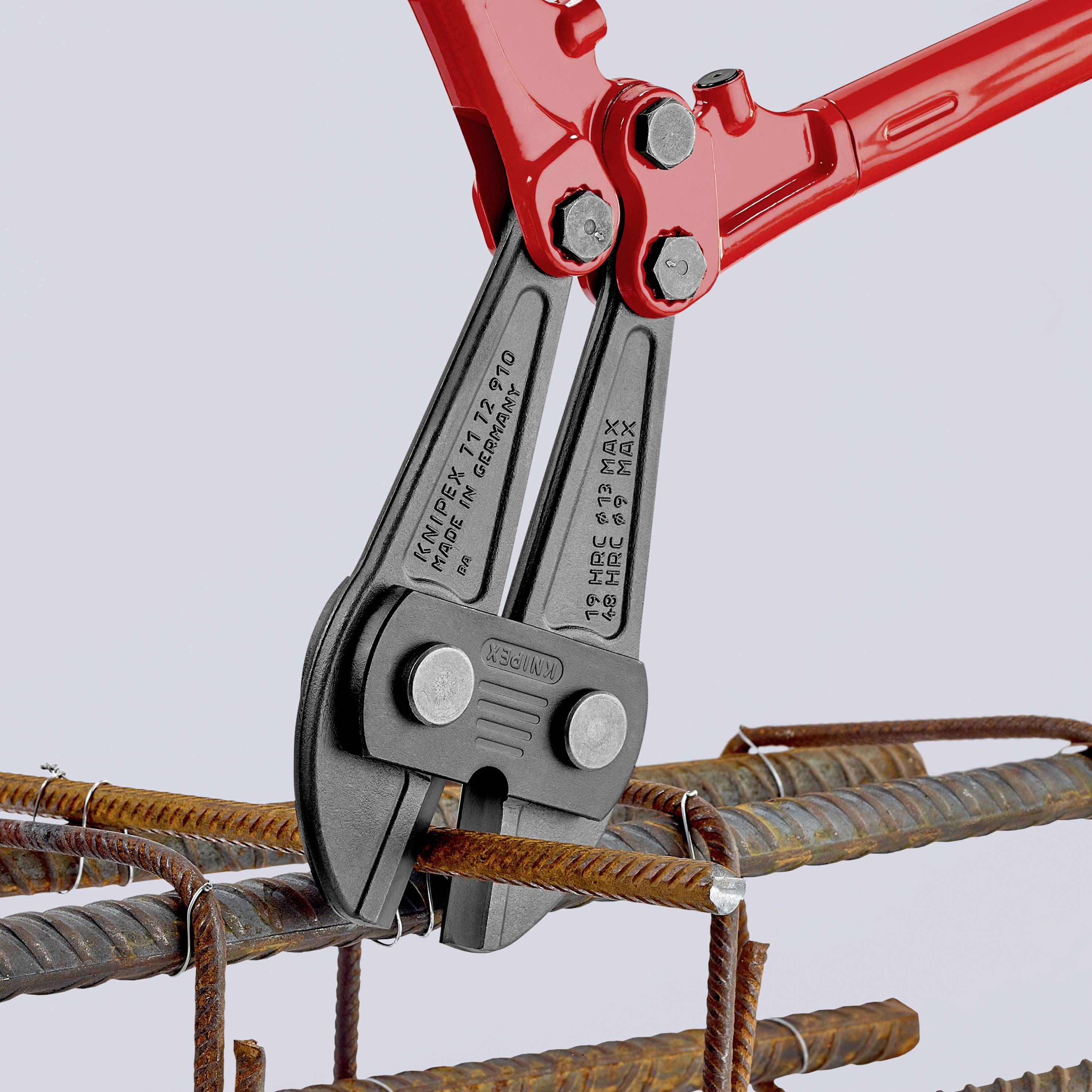 Eine rote Bolzenschneider schneidet Armierungseisen. Drei Stahlstäbe sind in einem Metallrahmen angeordnet.
