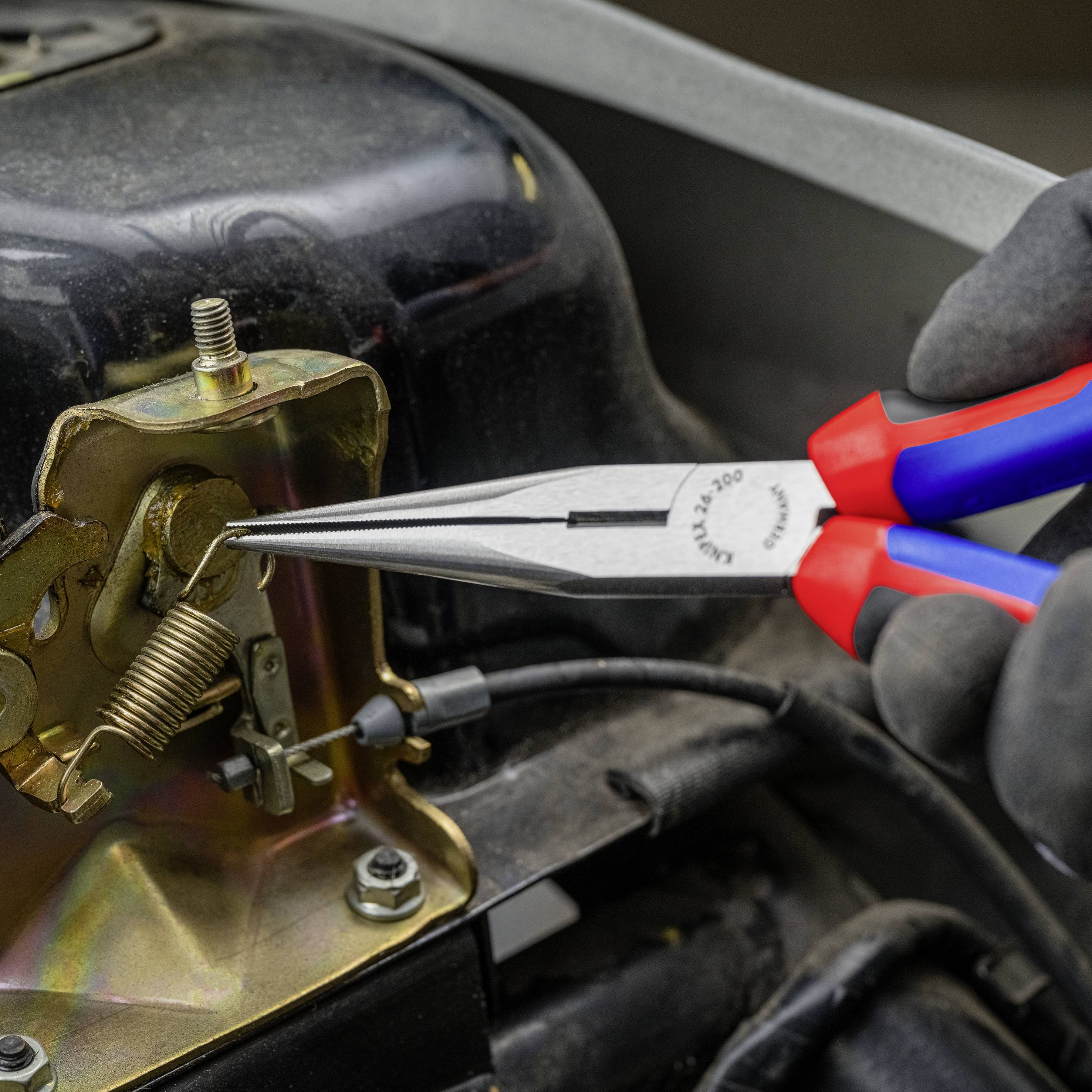 Eine Person hält eine Zange, um eine Schraubenfeder in einem mechanischen Teil zu befestigen. Es scheint eine Reparatur oder Anpassung zu sein.