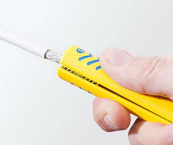 Eine Person hält ein gelbes Feuerzeug und zündet einen zylindrischen Gegenstand an. Der Fokus liegt auf dem Feuerzeug und dem Daumen, der den Zündmechanismus betätigt.