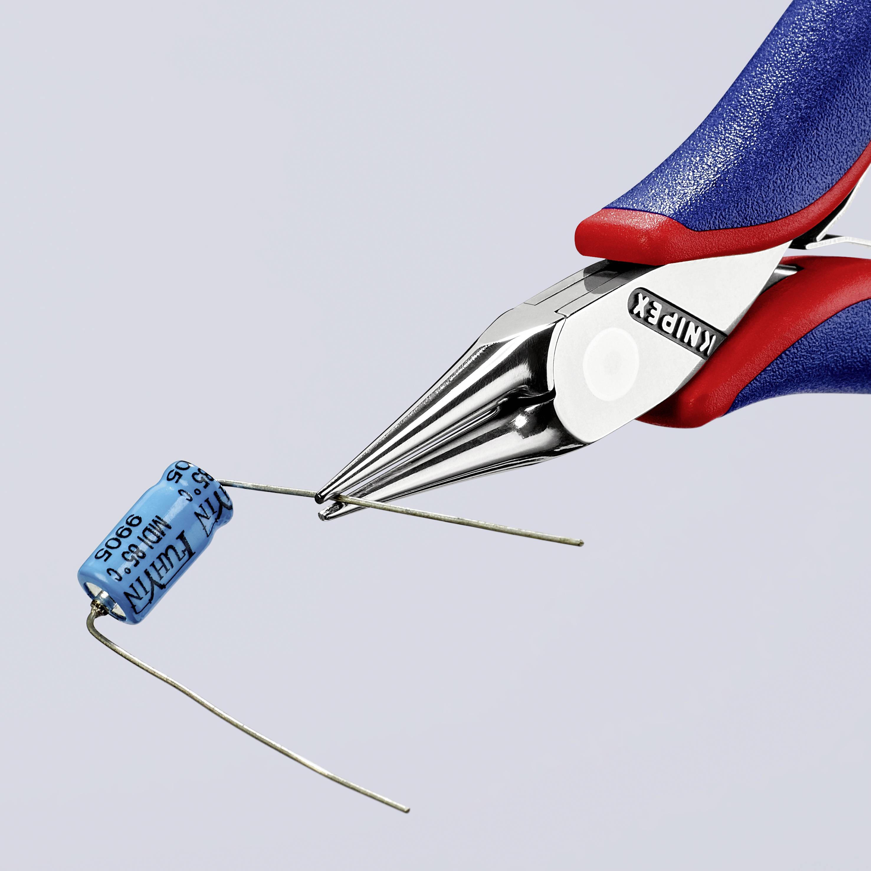 Die Bild zeigt eine Knipex-Zange, die einen blauen Kondensator hält und dessen Draht schneidet.