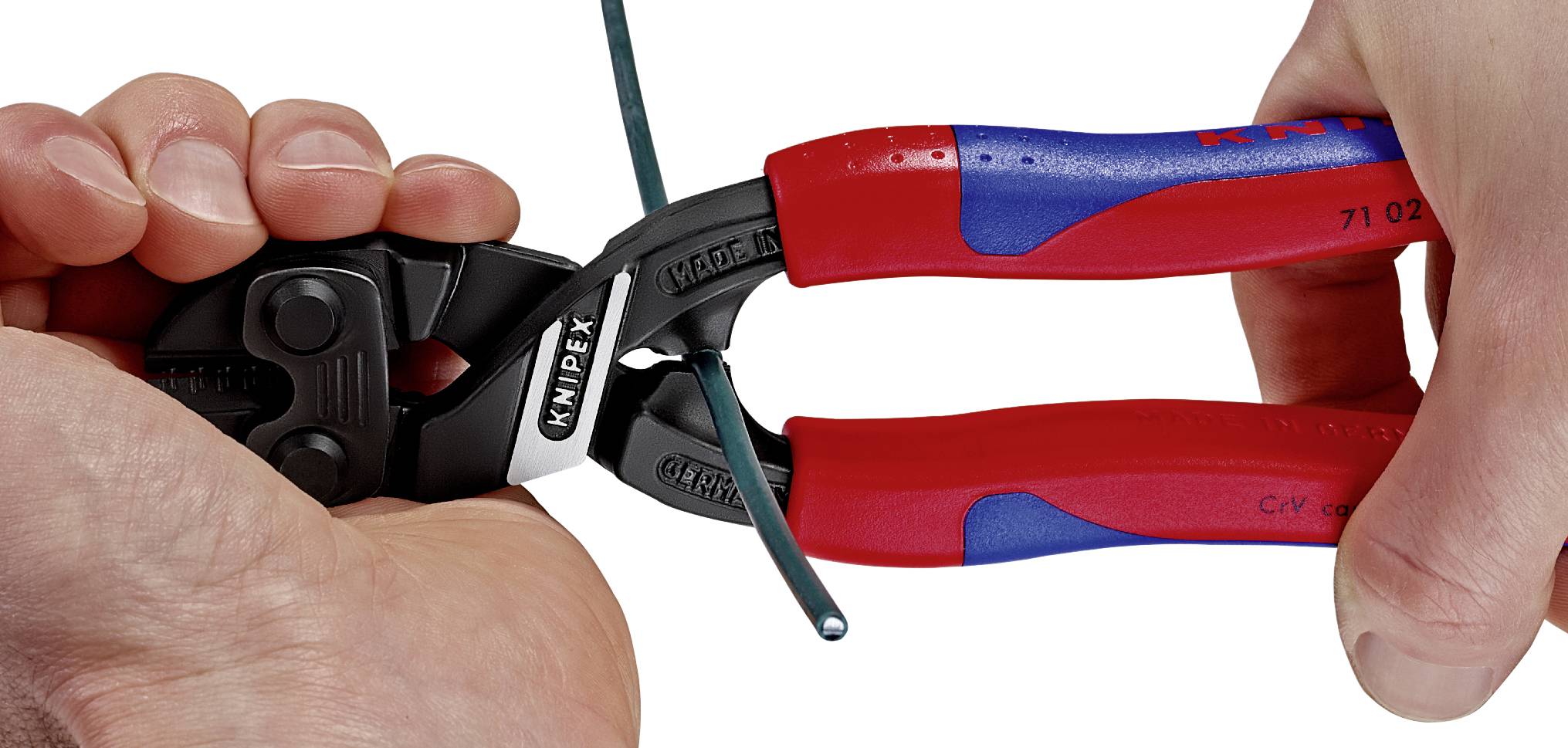 Eine Person benutzt einen roten und blauen Knipex-Kabelschneider, um ein grün ummanteltes Kabel abzutrennen.