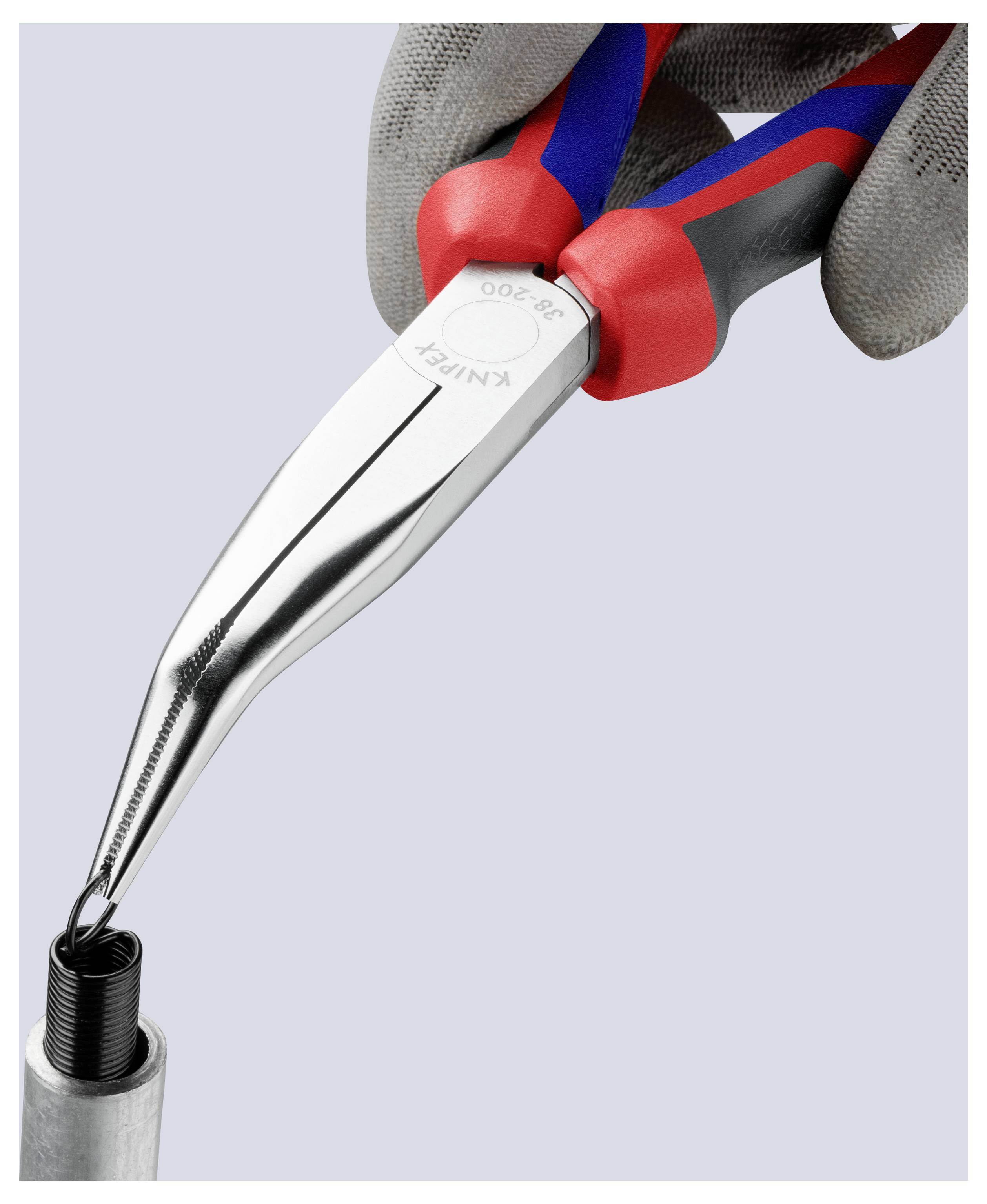 Eine Hand mit einem Handschuh benutzt eine Spitzenzange, um ein kleines Metallbauteil zu greifen.