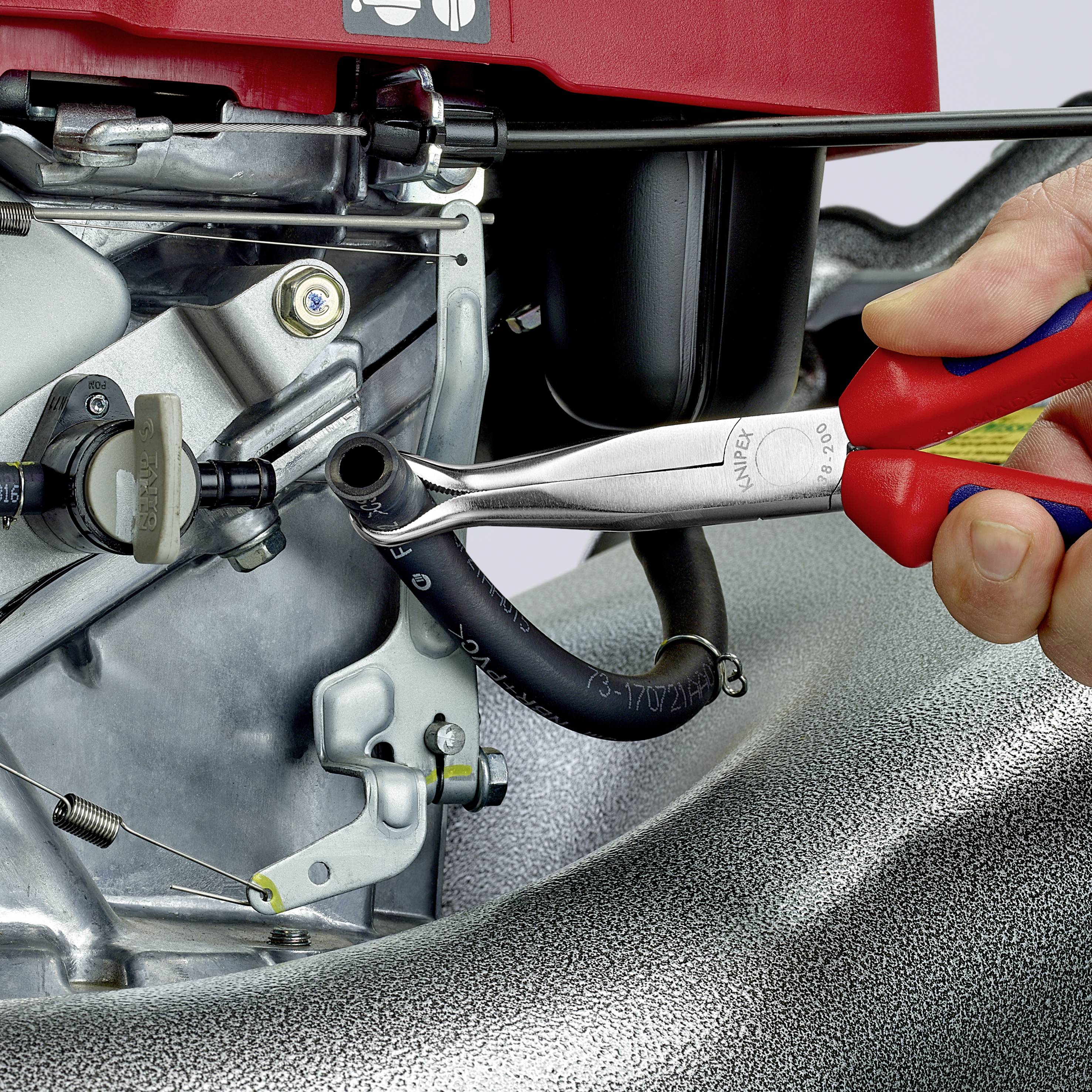 Ein Gabelschlüssel wird benutzt, um eine Schraube an einem Motor festzuziehen. Eine Hand hält das Werkzeug.