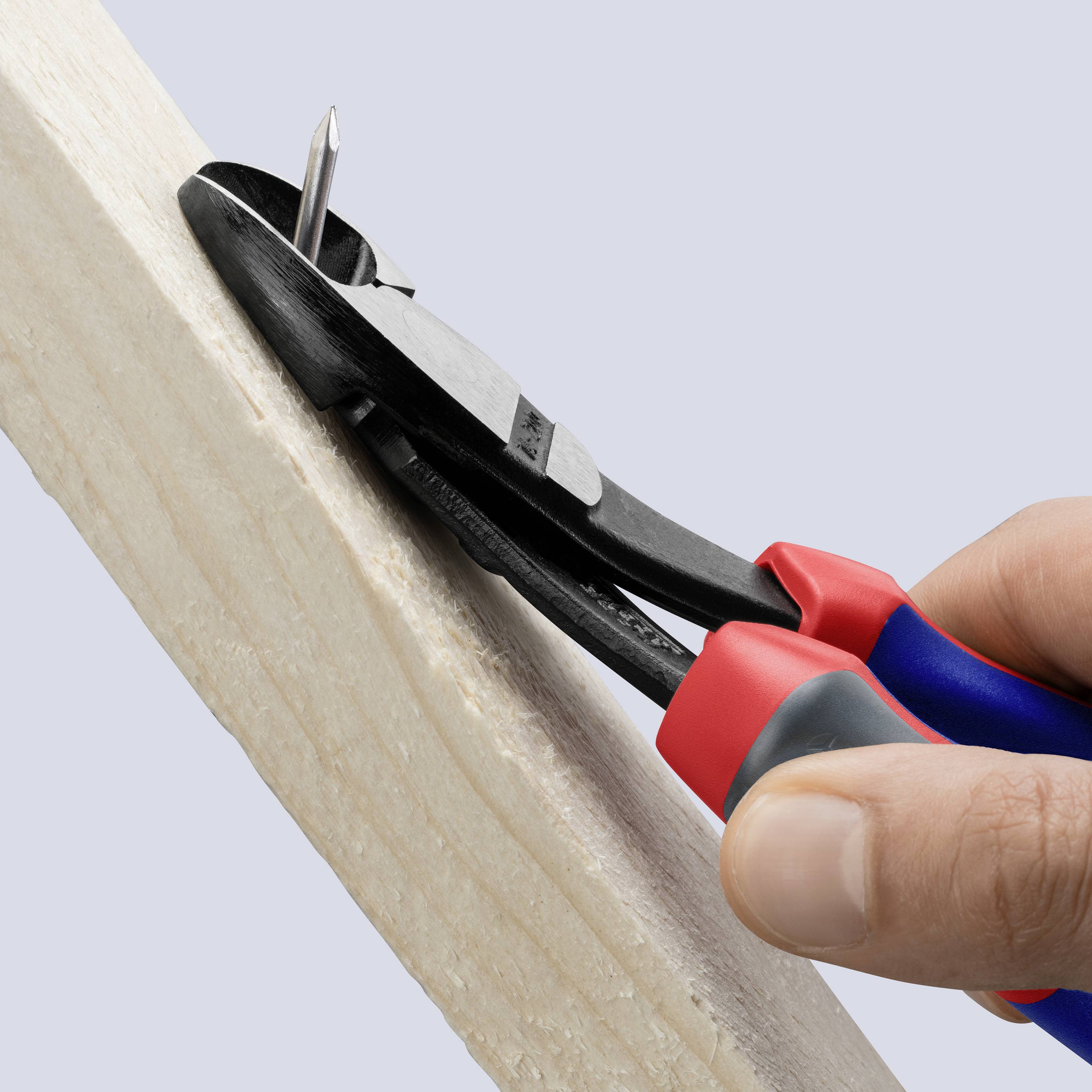 Eine Hand benutzt eine Kombizange, um einen Nagel aus einem Holzbrett zu entfernen.