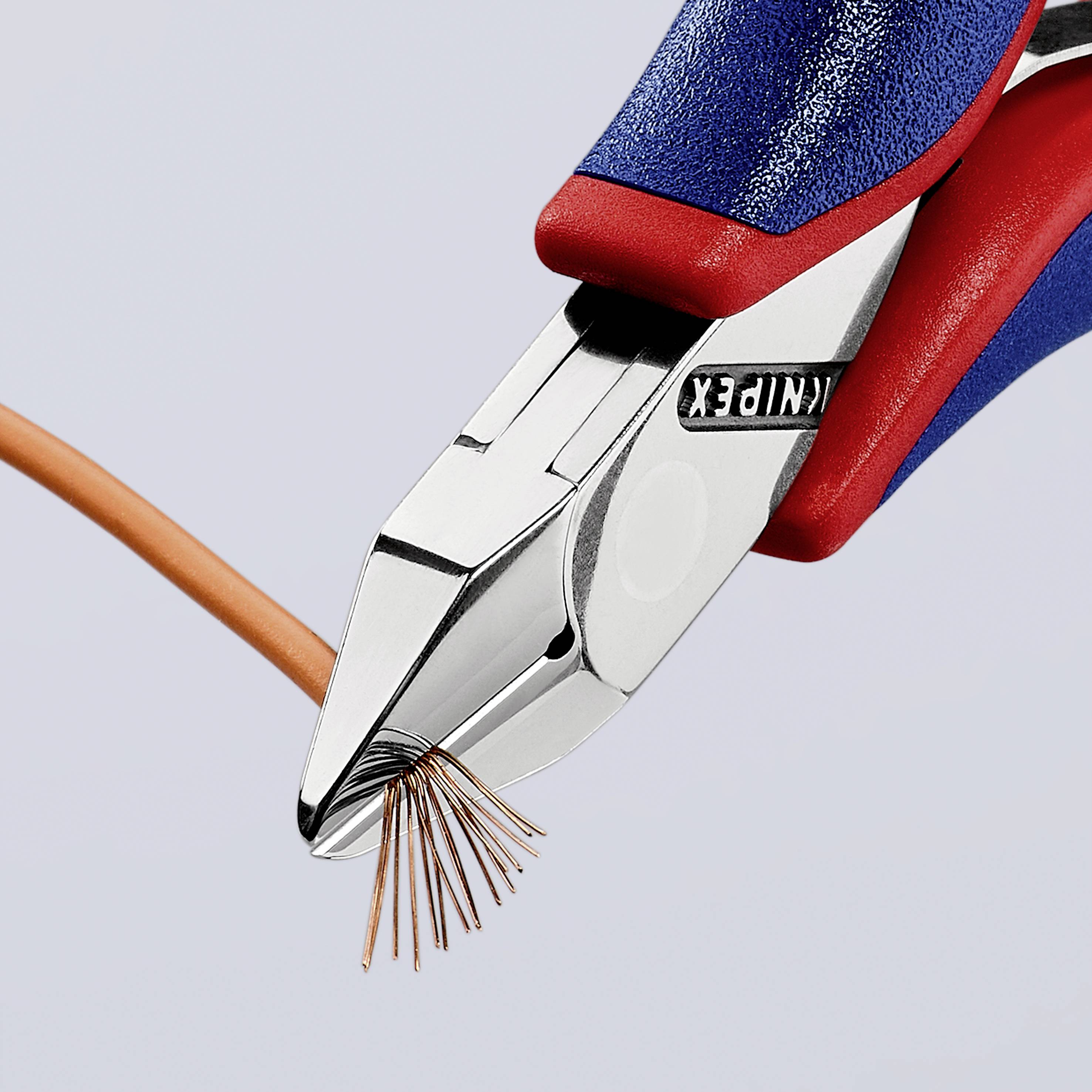 Eine Zange schneidet ein Kabel, wobei Kupferdrähte sichtbar sind. Das Werkzeug ist teilweise in Blau und Rot gehalten.