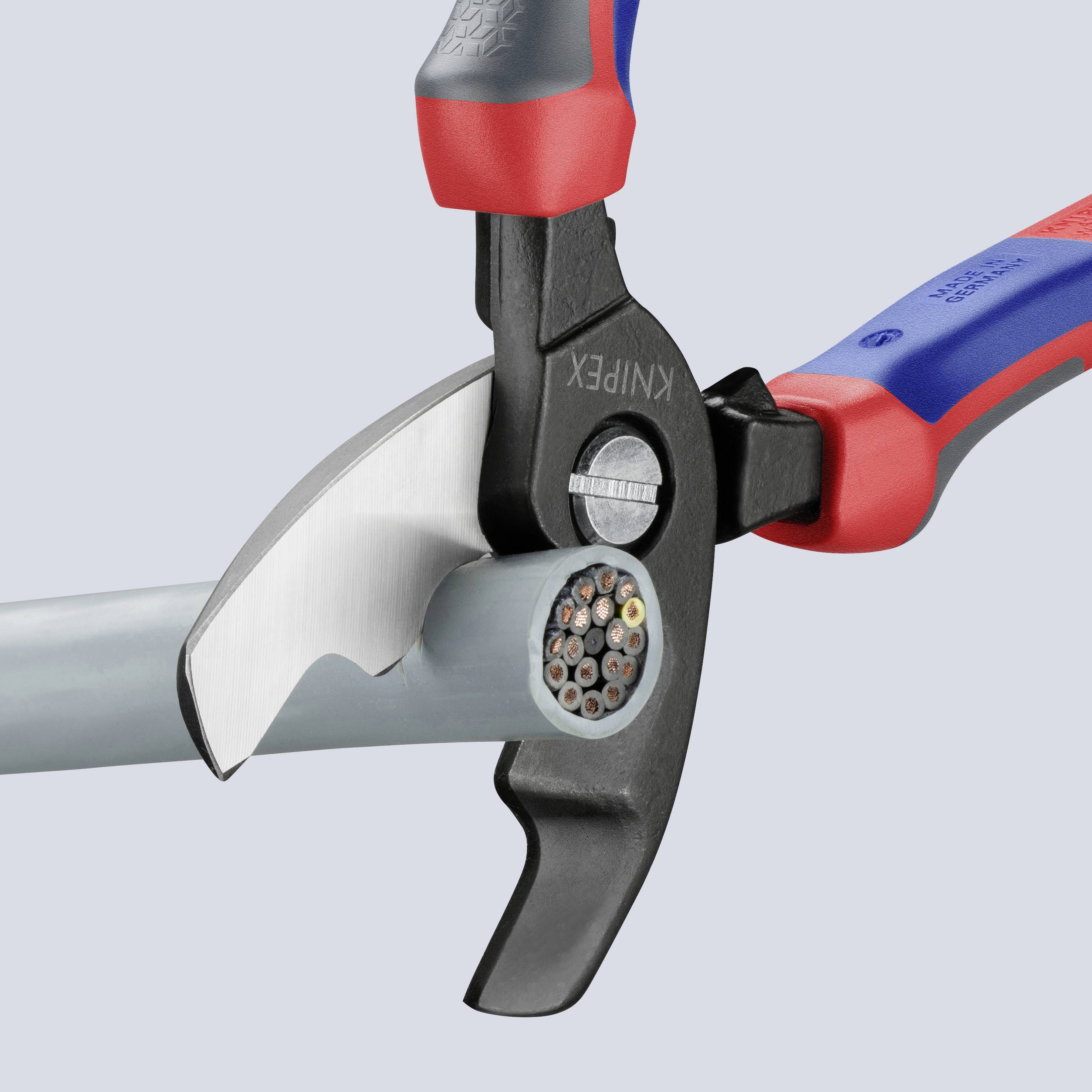 Eine elektrische Zange schneidet ein dickes Kabel mit Kupferdrähten. Die Zange hat rote und blaue Griffe für einen besseren Halt.
