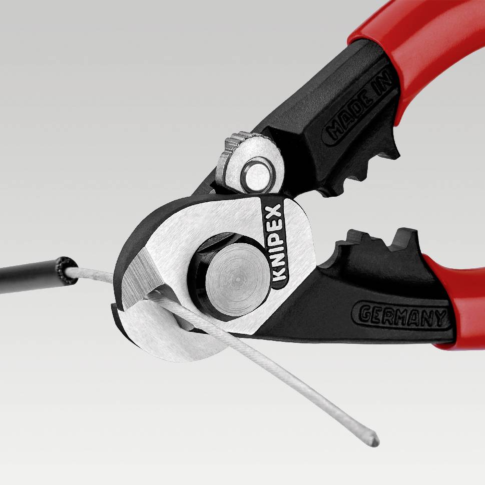 Eine Zange schneidet ein Kabel. Die Zange hat rote Griffe und die Klinge ist silbern. Der Hintergrund ist hellgrau.