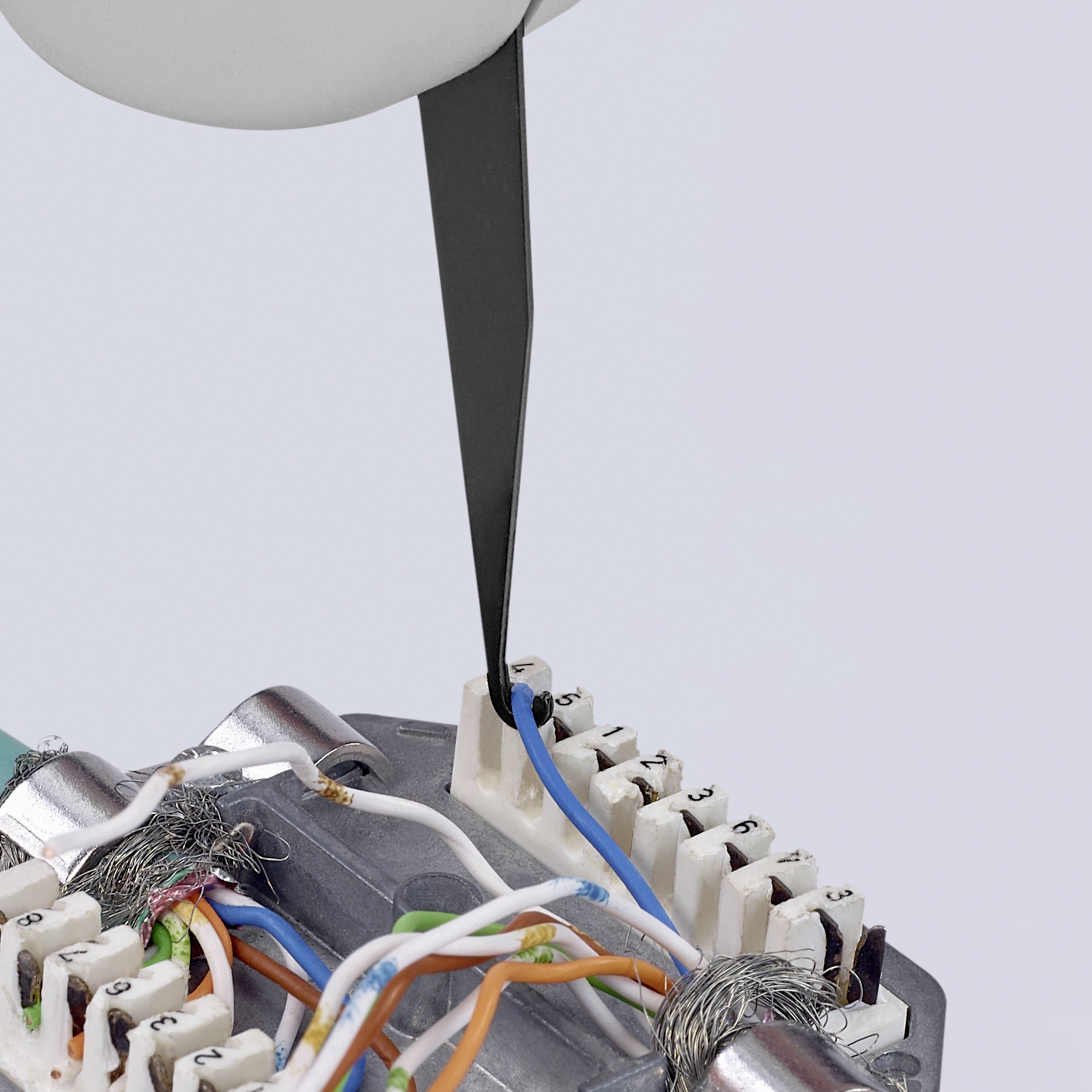 Ein Trennmesser trennt präzise bunte Kabel auf einer Leiterplatte. Deutlich sichtbar sind die freiliegenden Kabeladern.