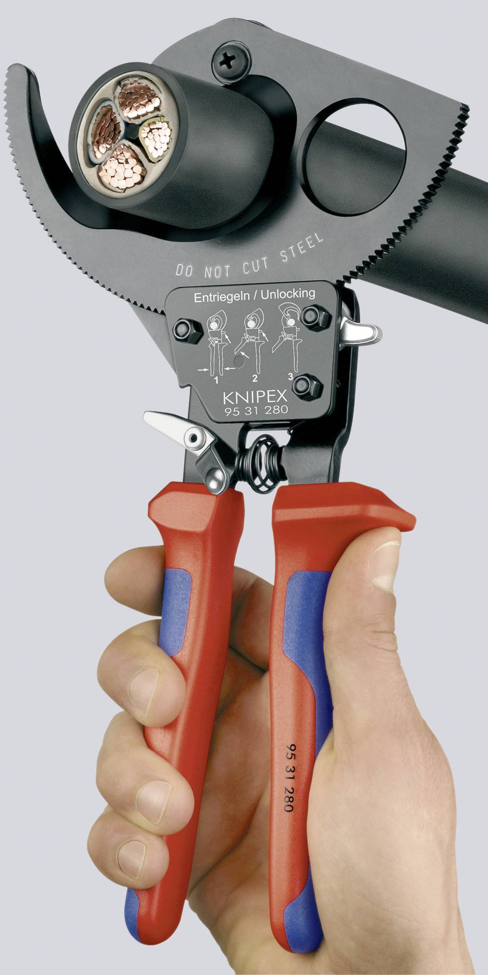Eine Hand hält einen Kabelschneider mit roten und blauen Griffen, bereit zum Schneiden eines dicken Kabels mit drei Kupferdrähten.
