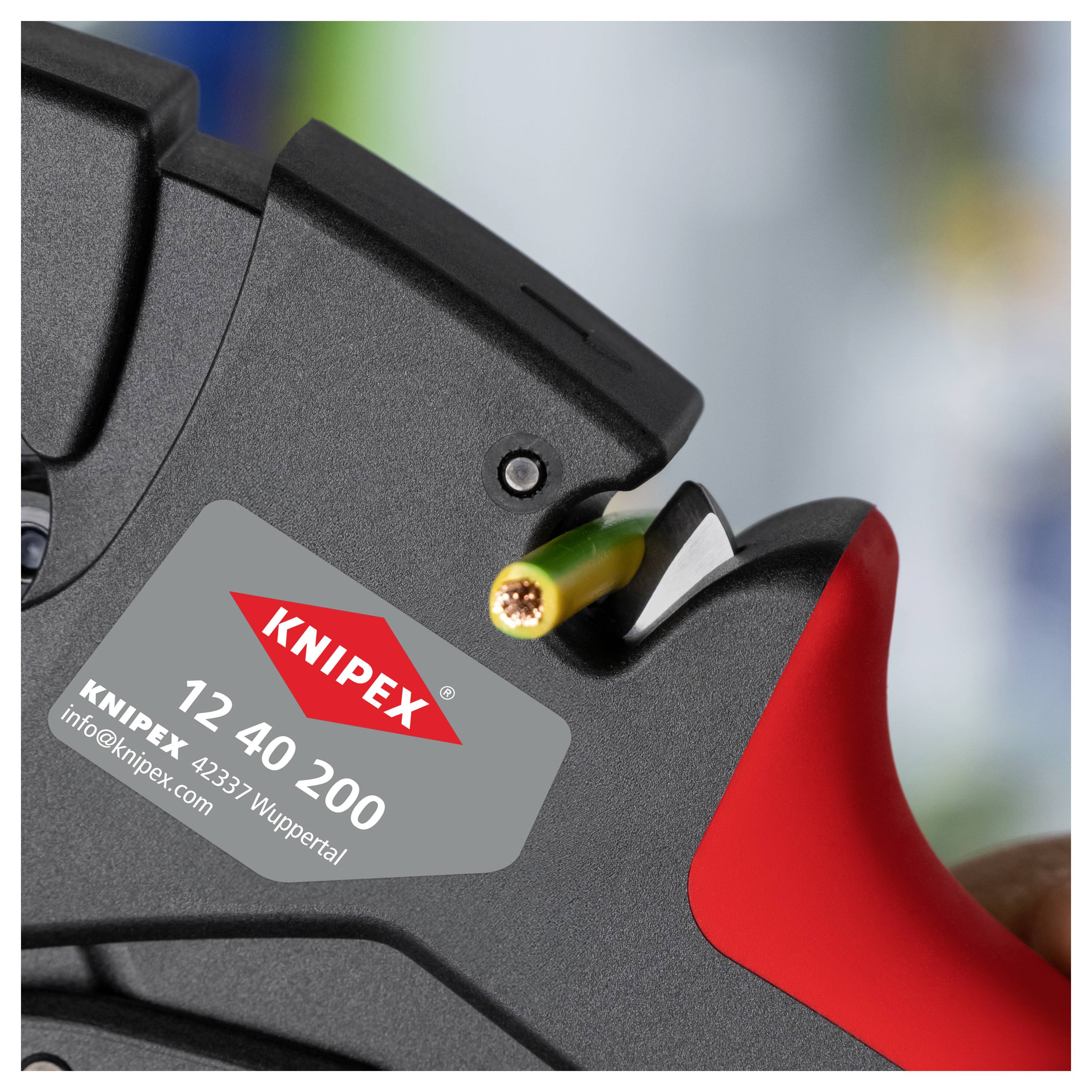 Abisolierzange aus der Nähe, gehalten mit einem teilweise abgeschälten grünen Kabel, bei dem kupferne Litzen sichtbar sind. Das Werkzeug trägt eine Beschriftung mit 'KNIPEX 12 40 200'.