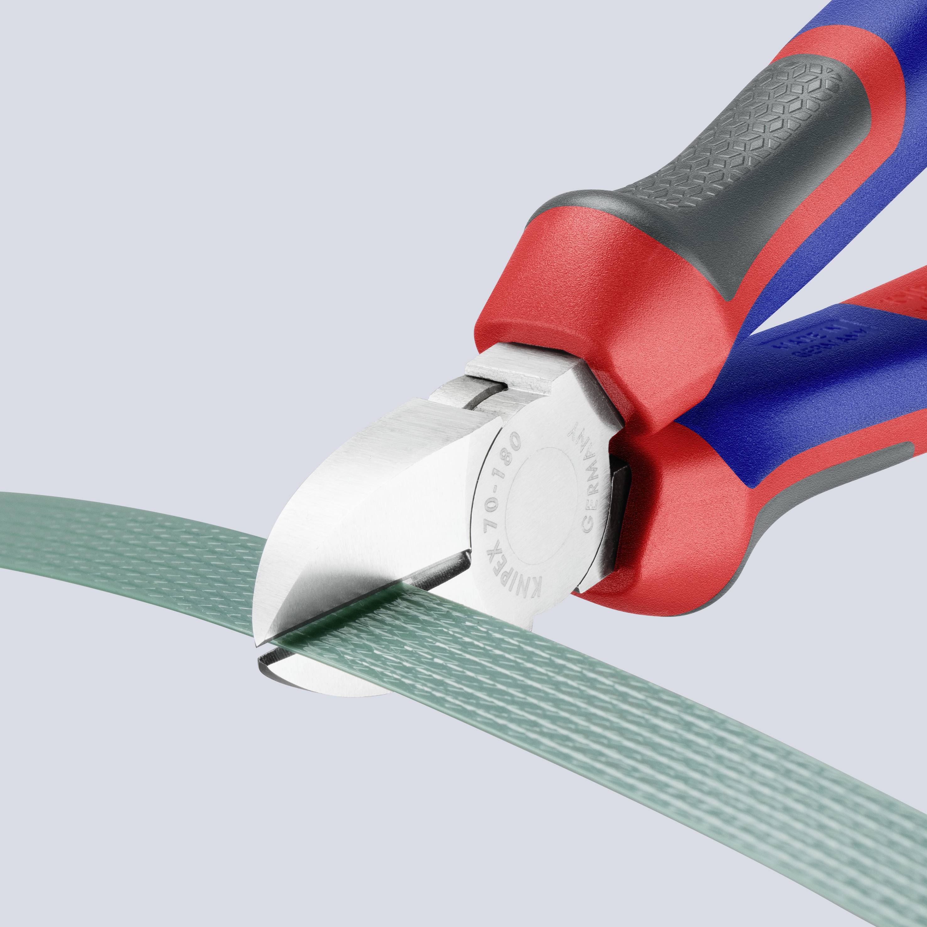 Zange durchtrennt grünes Kabel. Das Werkzeug hat rote und blaue Griffe und schneidet mit präzisen Backen.