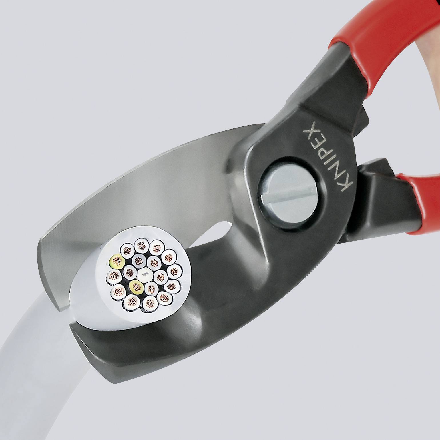 Zange schneidet ein Kabel mit mehreren bunten Drähten. Sie visualisiert Werkzeuggebrauch im Kontext von Elektrotechnik.