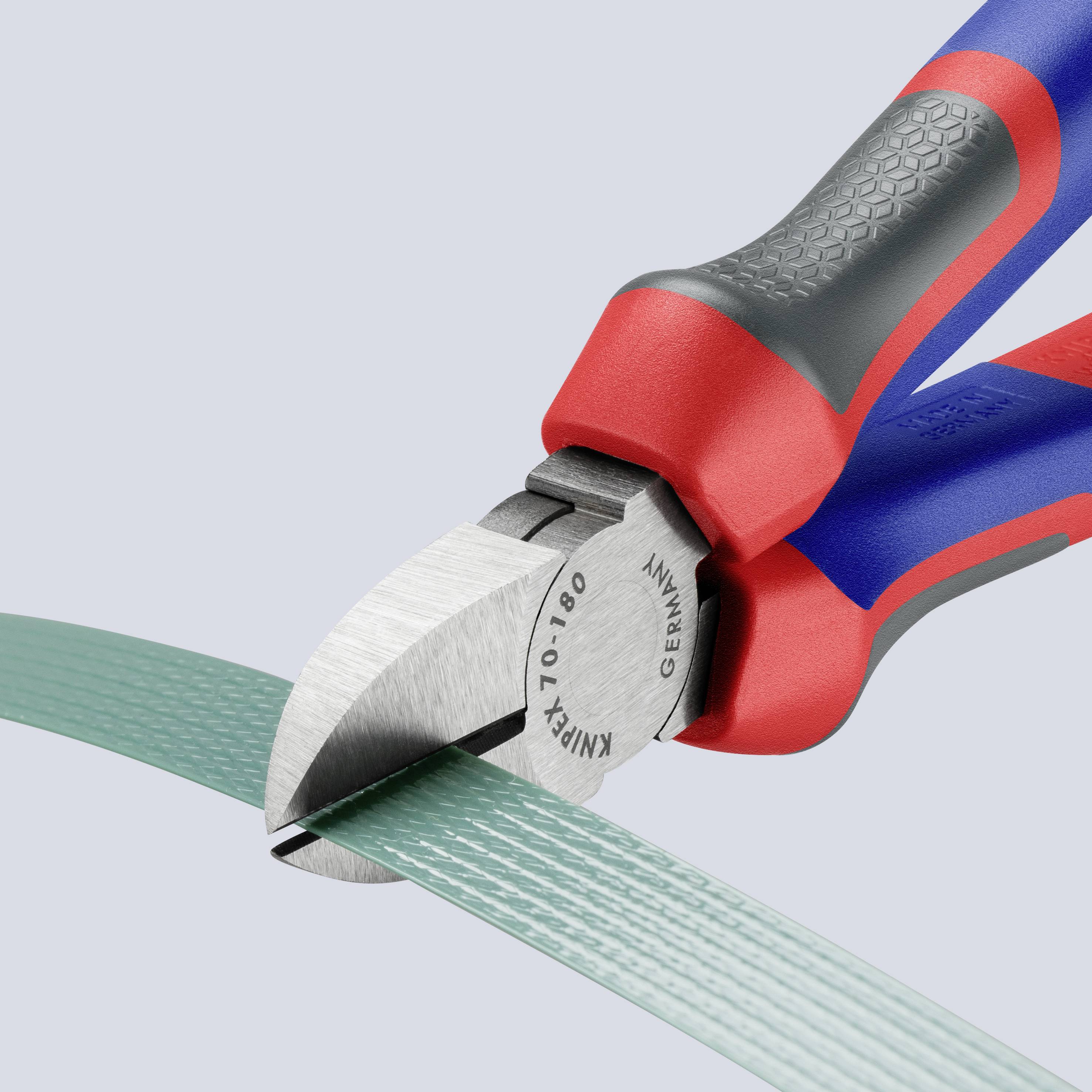 Seitenschneider schneidet ein grünes Kabel, grauer Hintergrund.