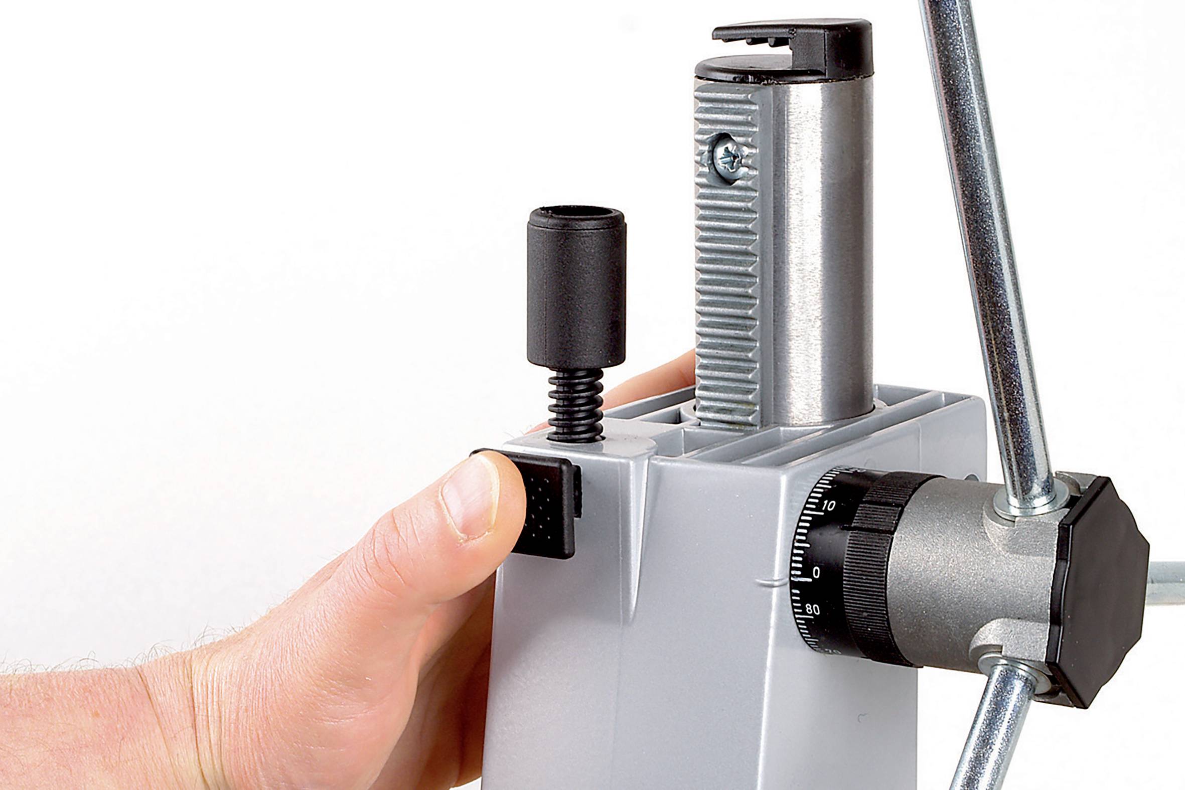 Hand betätigt eine mechanische Vorrichtung mit einem Hebel und einem Knopf.