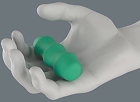 Eine Graustufenhand hält einen grünen, dreigeteilten Gegenstand, der einem Puzzleteil oder einem Stressball ähnelt, vor einem grauen Hintergrund.