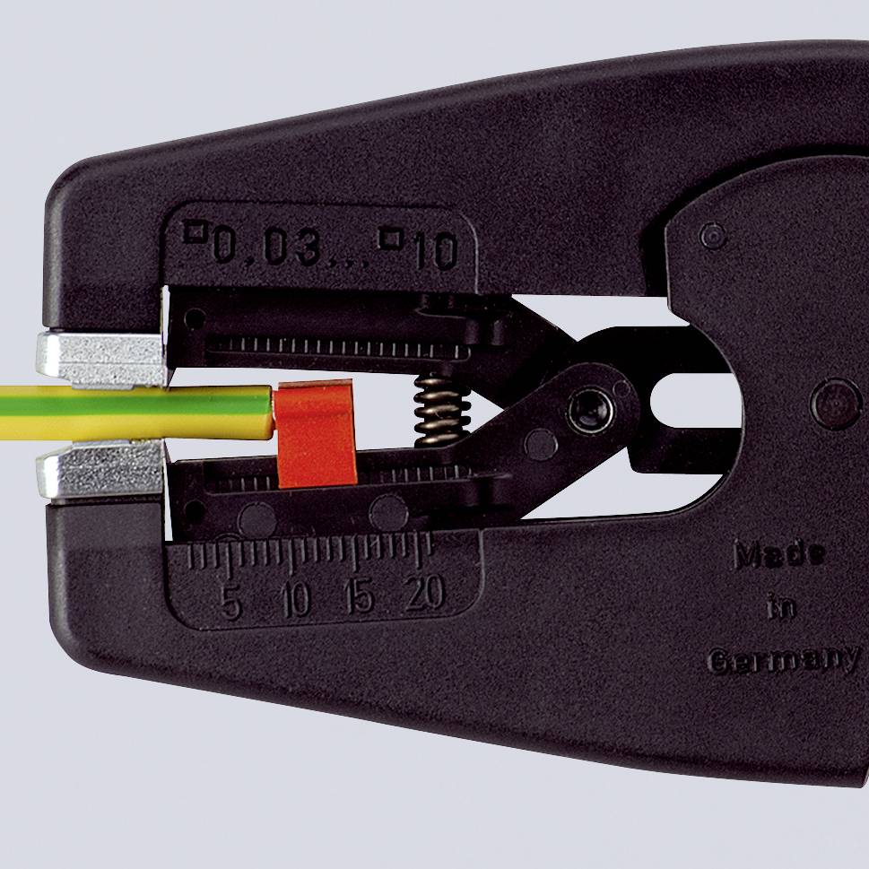 Eine Crimpzange, die ein Kabel mit gelb-grüner Isolierung abisoliert. Skala zeigt Maße für Präzision an.