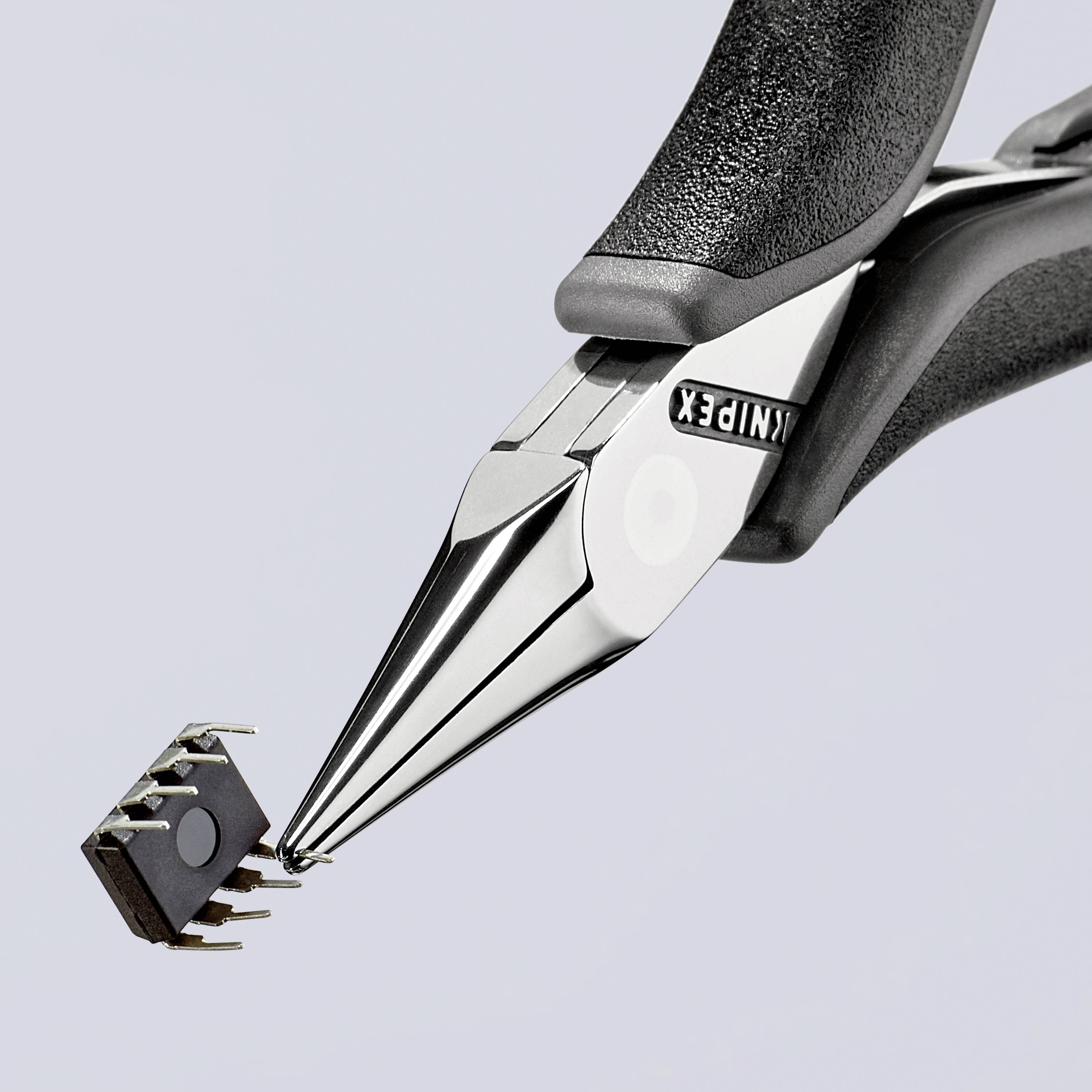 Eine Zange hält einen kleinen Mikrochip, der mehrere Anschlusspins hat.