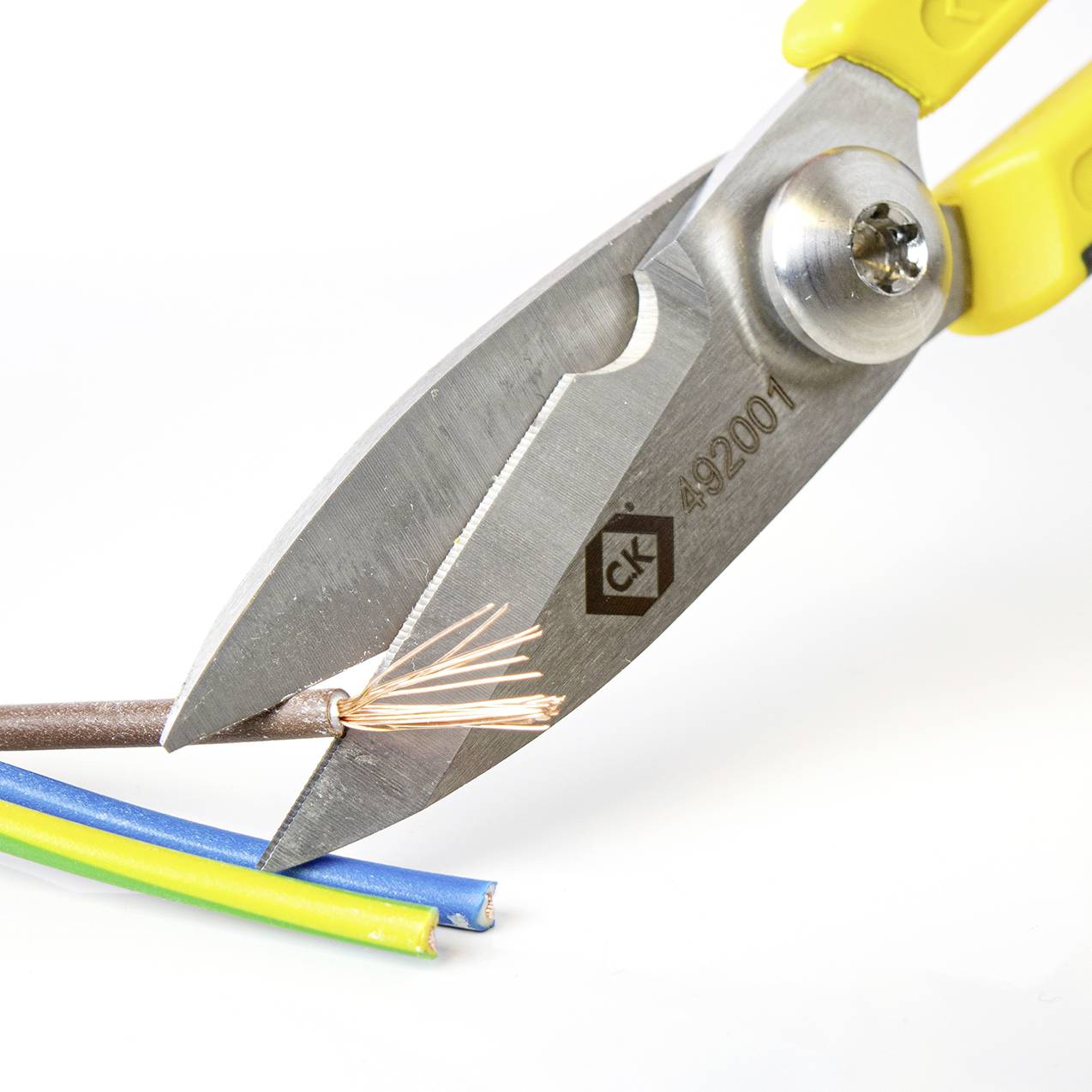 Eine Zange schneidet ein elektrisches Kabel, das aus mehreren farbigen Drähten besteht.