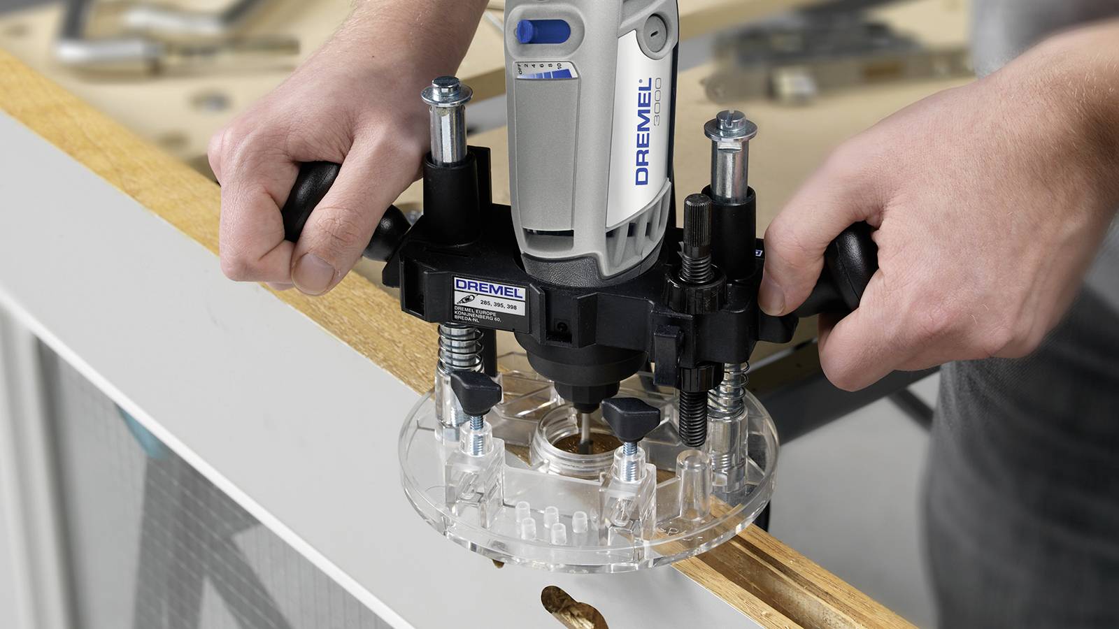 Eine Person verwendet einen Dremel-Fräseinsatz, um präzise Formen in einem Holzstück zu schneiden.
