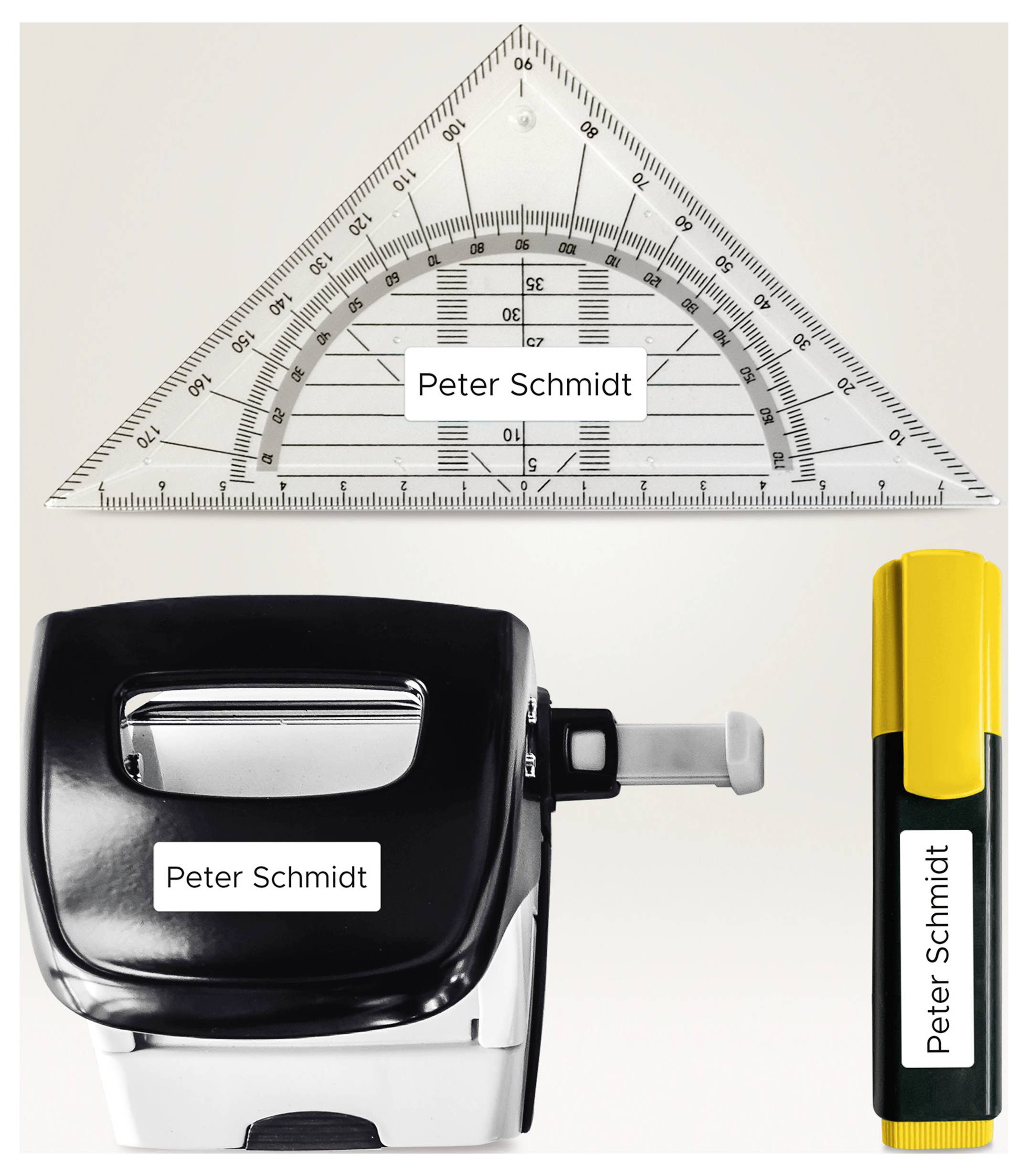 Schulischer Zeichen- und Lochwerkzeugsatz mit Lineal, Heftgerät und Textmarker, jeweils mit dem Namen 'Peter Schmidt' beschriftet.