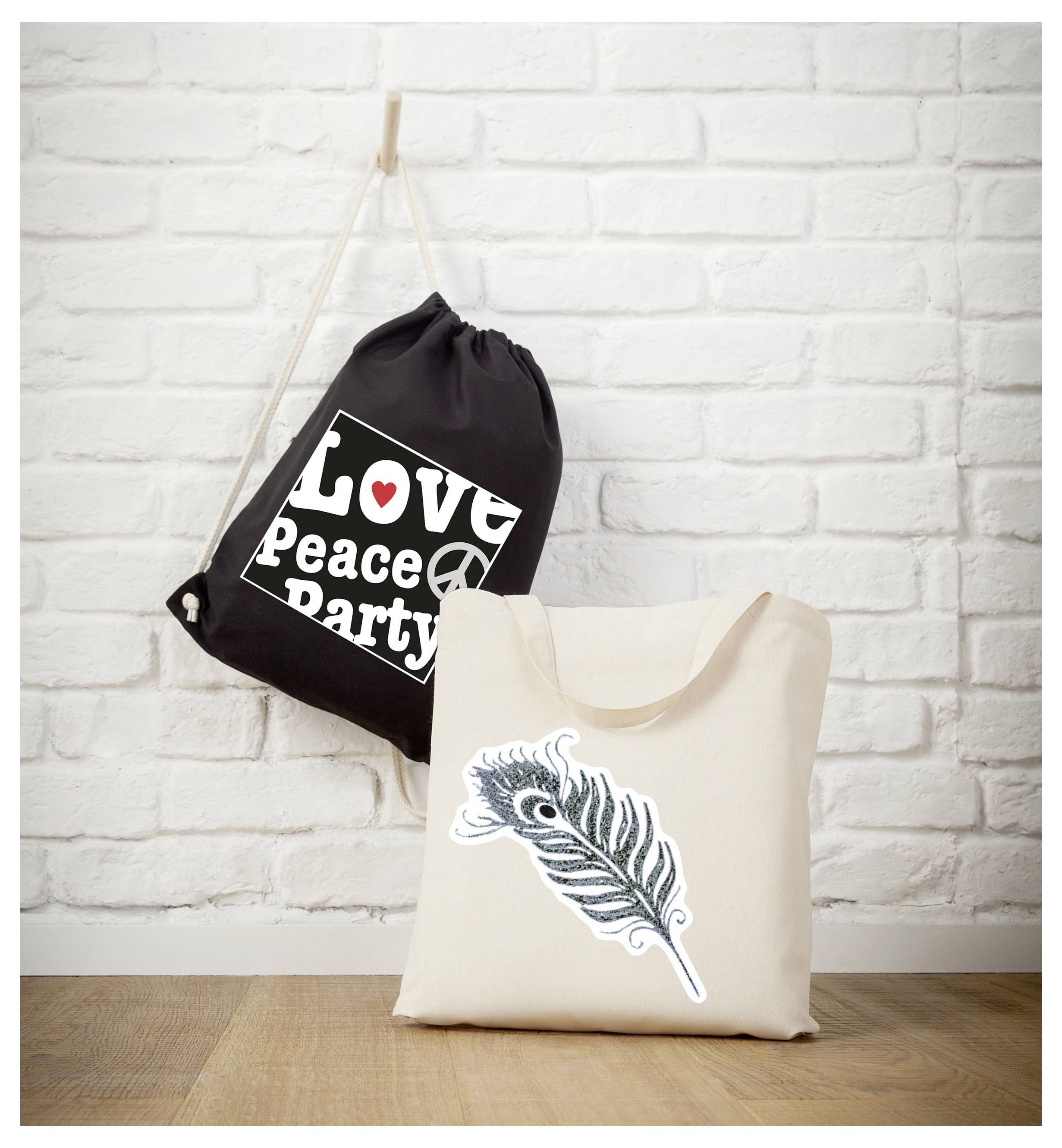 Beiger Stoffbeutel mit Feder-Motiv vor weißer Backsteinwand; dahinter schwarzer Turnbeutel mit Aufdruck 'Love Peace Party'.