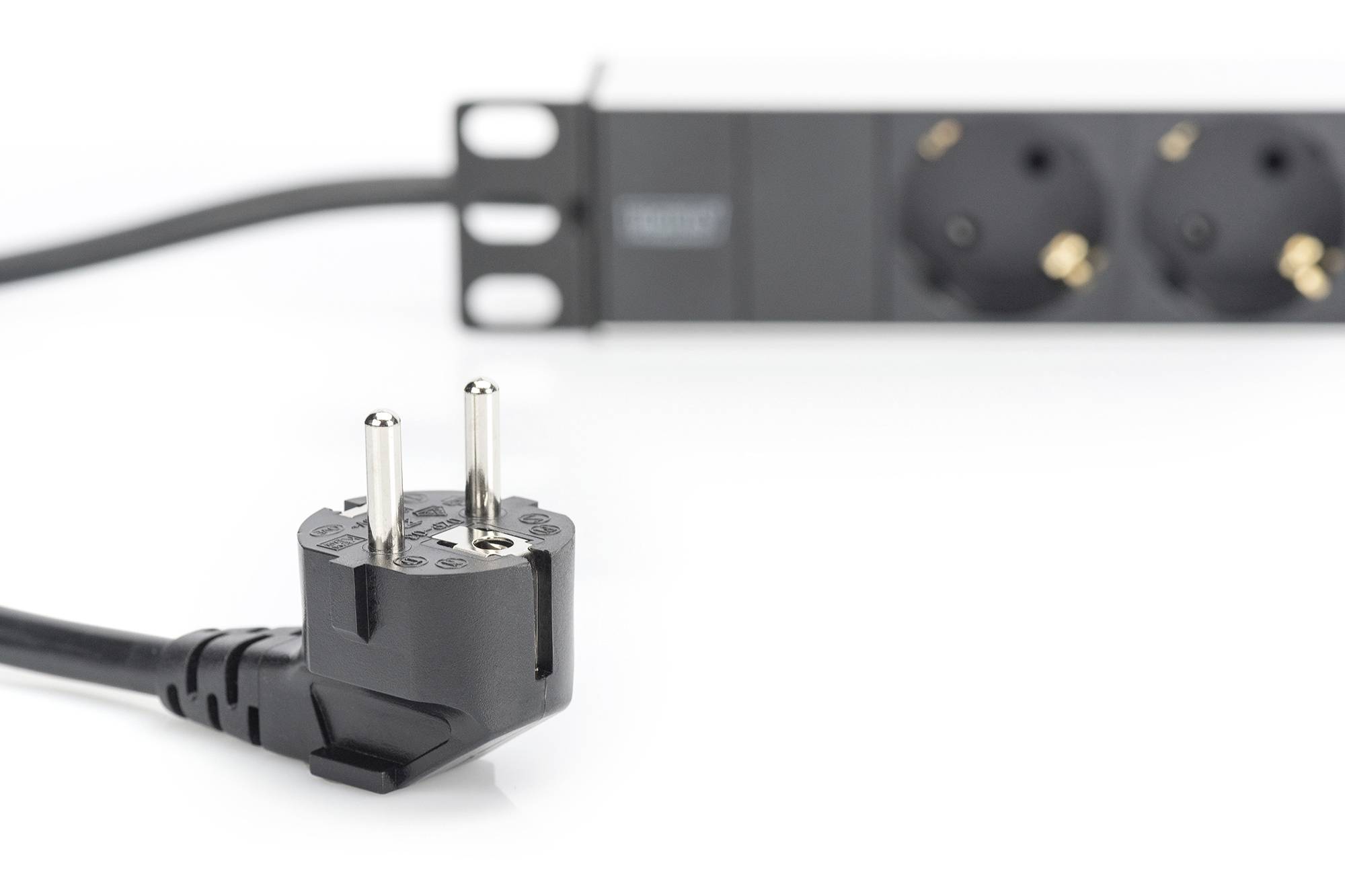 Ein schwarzer Eurostecker liegt vor einer Mehrfachsteckdose.