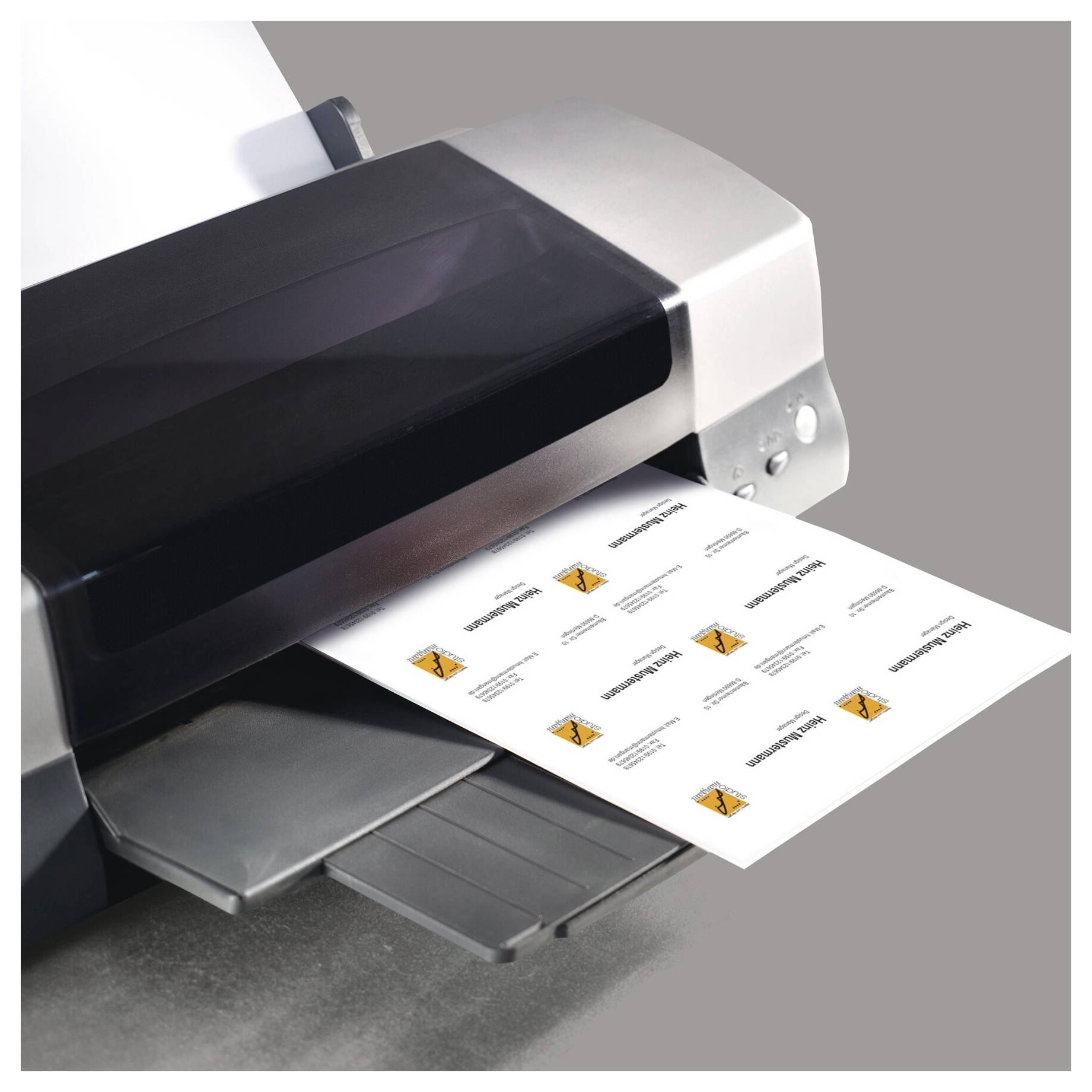 Großformatdrucker, der ein Blatt mit Etiketten oder Schildern mit kleinen orangefarbenen Warnsymbolen ausgibt.