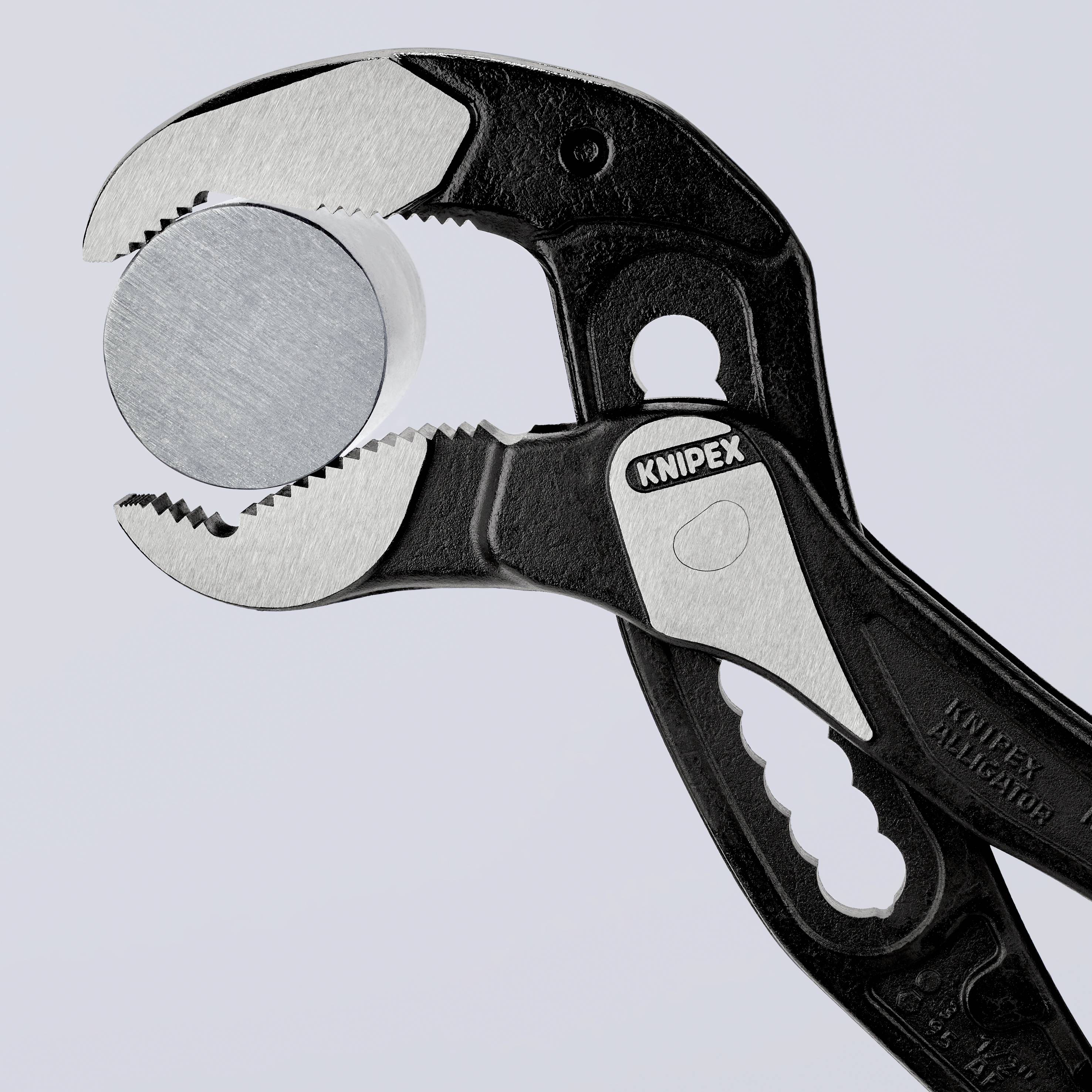 Eine schwarze Knipex-Zange hält einen runden, metallisch glänzenden Gegenstand, vermutlich eine Münze, fest in ihrem Greifbereich.