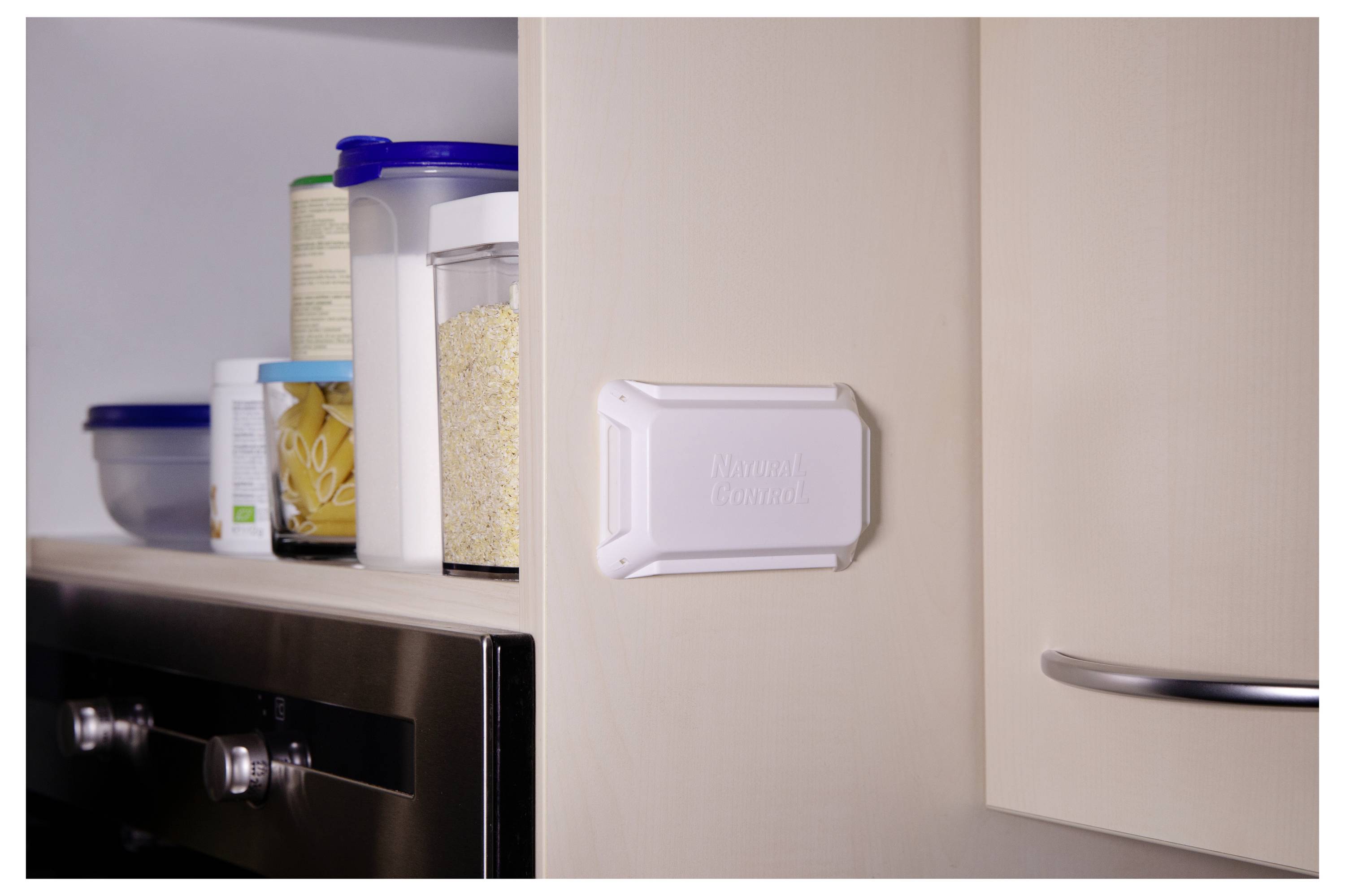 Ein Vorratsregal mit verschiedenen Lebensmittelbehältern neben einem Ofen; ein weißes Gerät mit der Beschriftung 