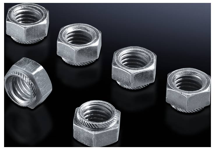 Sechs silberne Sechskantmuttern liegen verstreut auf einer dunklen Oberfläche.