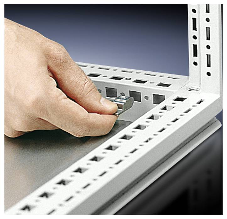 Eine Hand montiert ein Metallteil in einen weißen Rahmen mit Lochmuster. Dies scheint ein technisches oder industrielles Gerät zu sein.