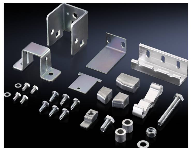 Verschiedene Metallbeschläge und Schrauben auf dunklem Hintergrund. Enthält Winkel, Halterungen und Befestigungselemente in verschiedenen Formen und Größen.