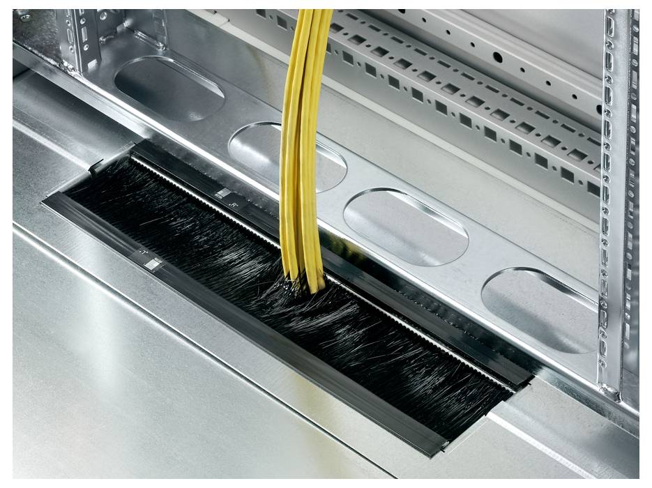 Gelbe Kabel führen durch eine Bürstenleiste in einem metallischen Servergehäuse zur Kabelführung und Reduzierung von Staub.