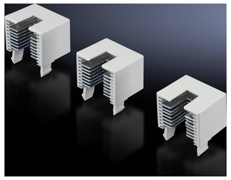 Drei weiße, L-förmige Kunststoffobjekte auf dunklem Hintergrund, der Details der Geometrie und Stapelform zeigt.