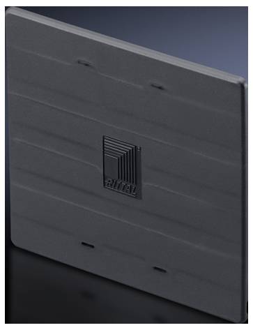 Graues Metallteil mit Rillen, Logo 'Rittal' in der Mitte. Das Teil steht schräg auf einer dunklen Oberfläche.
