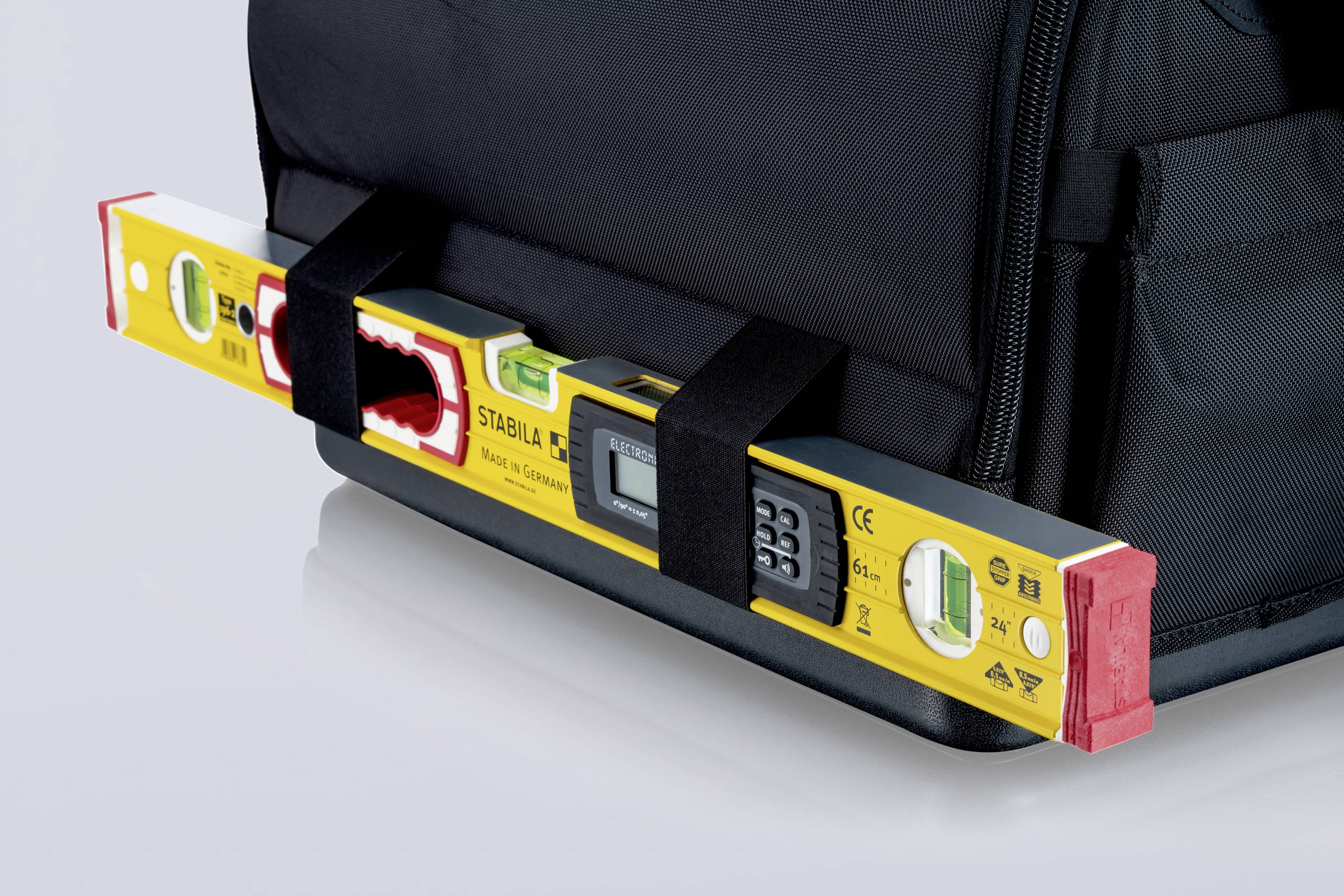 Wasserwaage mit digitalen Anzeigen in Halterungen an einer Werkzeugtasche befestigt.