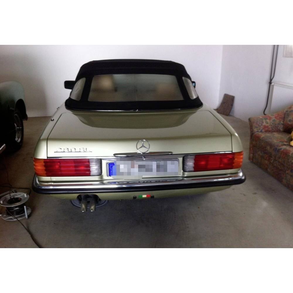 Ein Vintage Mercedes-Benz-Wagen mit Cabrio-Verdeck und Chromdetails, von hinten in einer Garage geparkt.