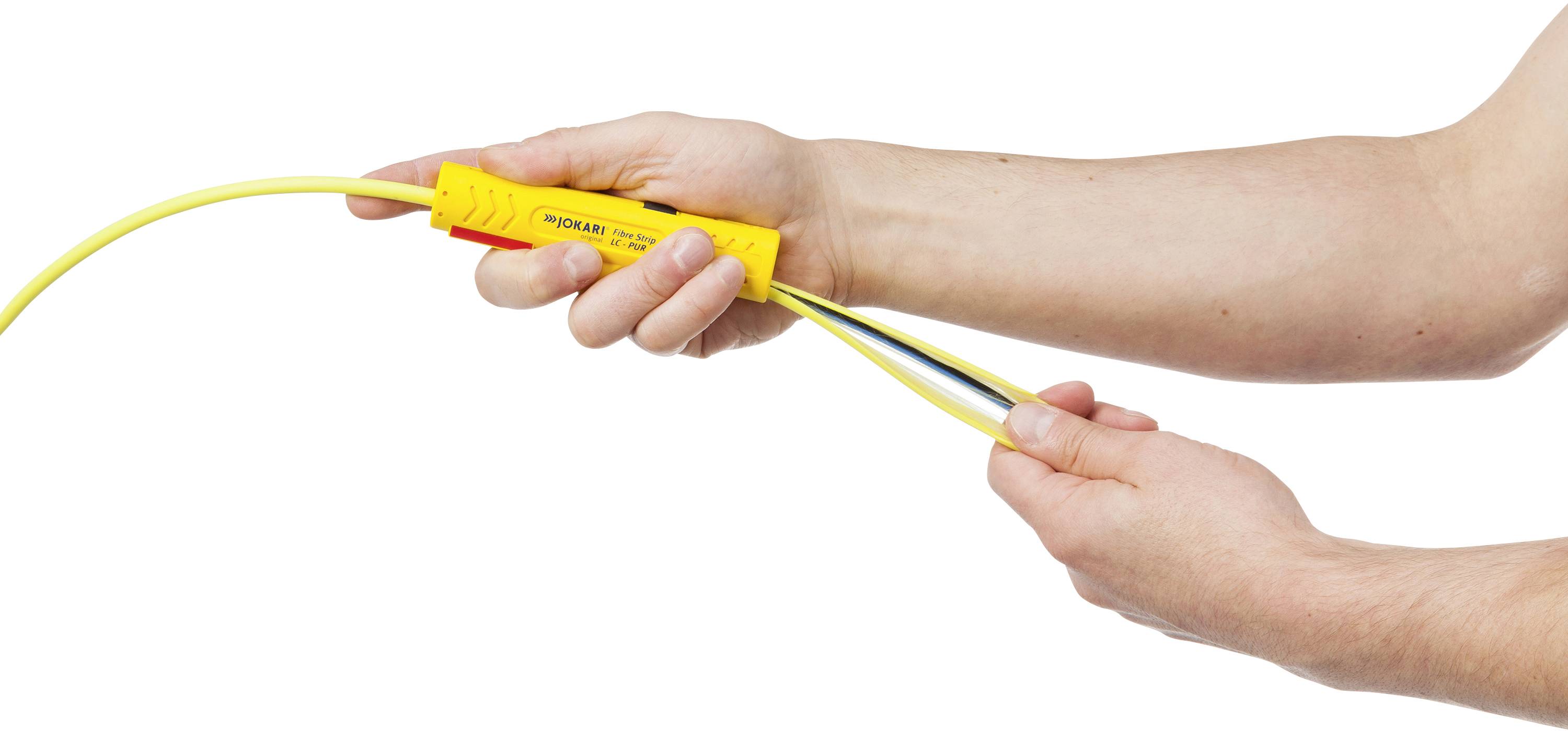 Hände halten ein Spannungsprüfergerät, das an ein gelbes Kabel angeschlossen ist.