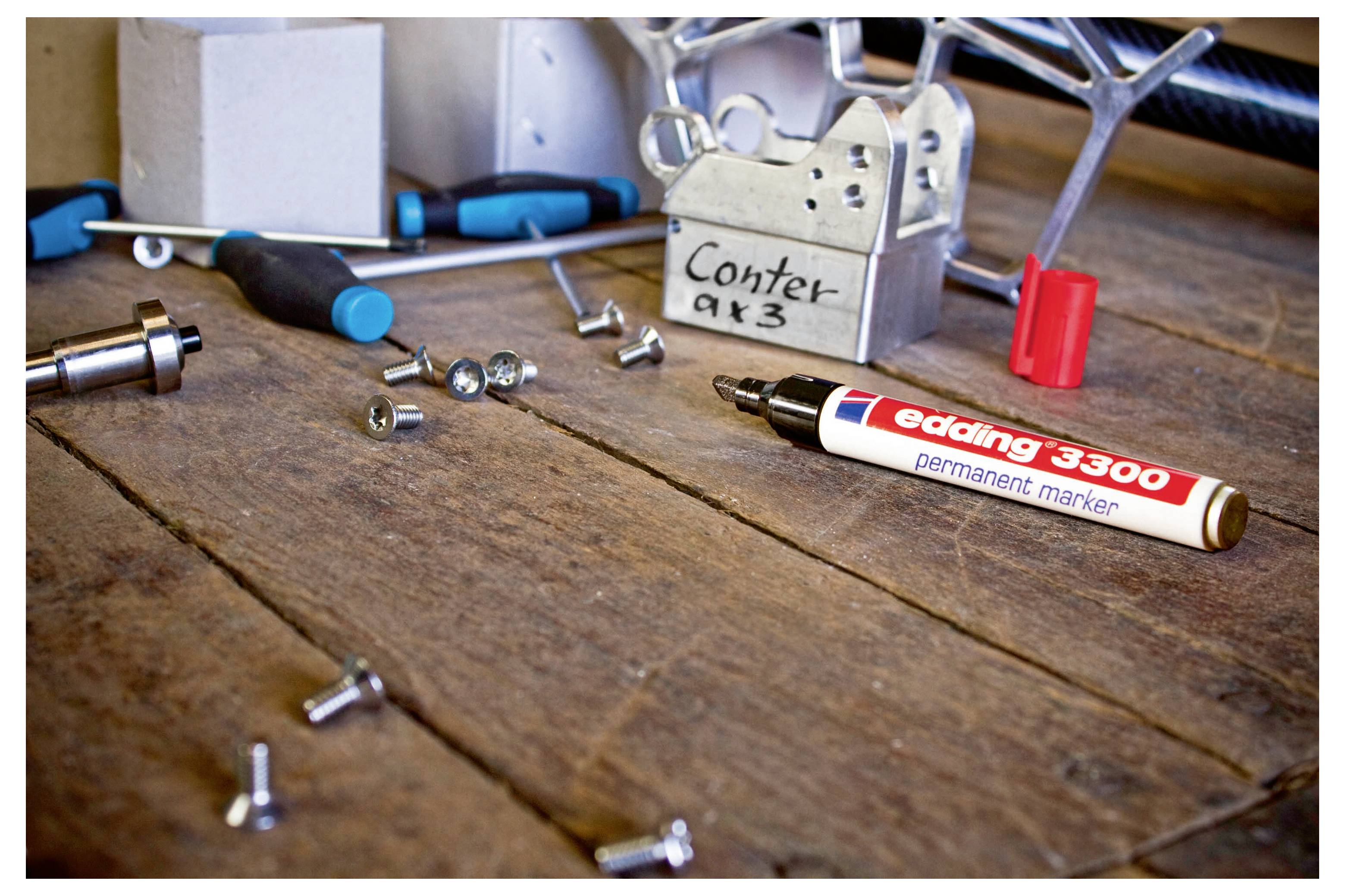 Ein Vorhängeschloss mit der Bezeichnung „Counter x3" sitzt auf einer Holzwerkbank neben verstreuten Schrauben, Werkzeugen und einem roten Marker.