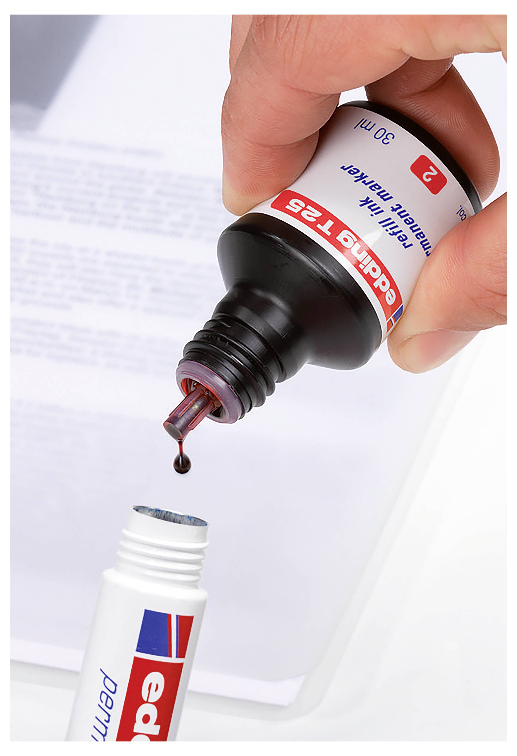 Eine Hand drückt Augentropfen aus einer Flasche in einen offenen Augentropfenbehälter auf einer weißen Oberfläche.