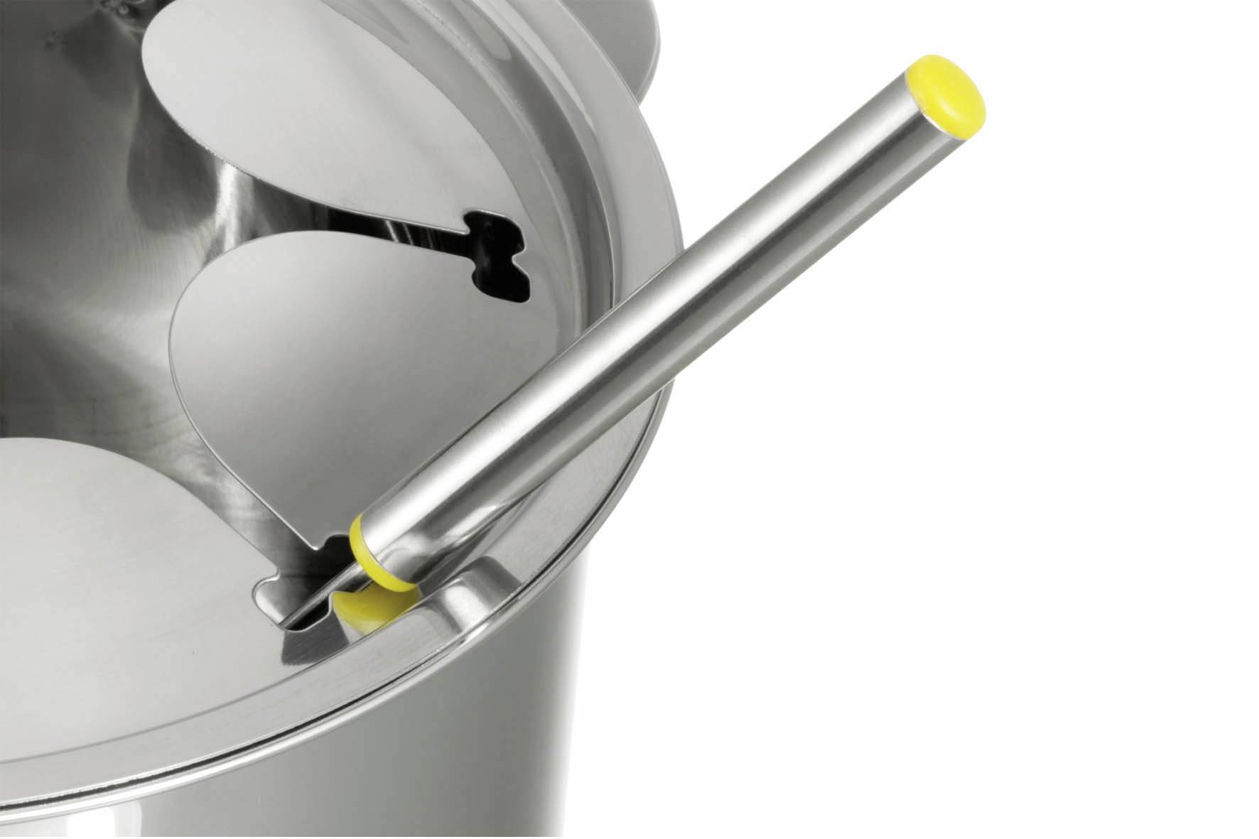 Ein Topf mit Deckel in Herzform und einem gelben Griff an einem Metallstab.