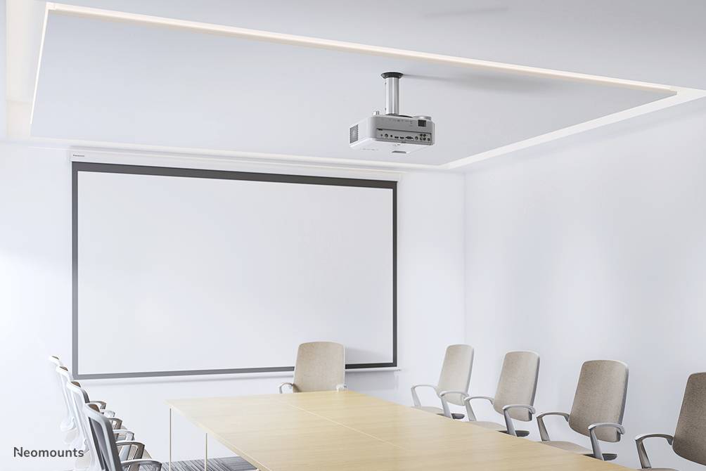 Konferenzraum mit weißem Projektor an der Decke, einem großen Leinwand-Bildschirm an der Wand und einem langen Holztisch mit acht Stühlen.