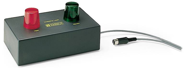 Ein rechteckiges Gerät mit einem roten und einem grünen Knopf, daran angeschlossener Kabel mit Stecker. Beschriftet: 'Test' und 'Ready'.