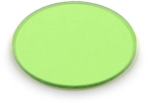 Ein grüner Glasfilter in kreisförmiger Form, auf einer weißen Oberfläche liegend.
