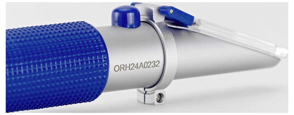 Nahaufnahme eines Metallwerkzeugs mit einem strukturierten blauen Griff und einem transparenten Kunststoffprisma oben, gekennzeichnet mit „ORH24A0232