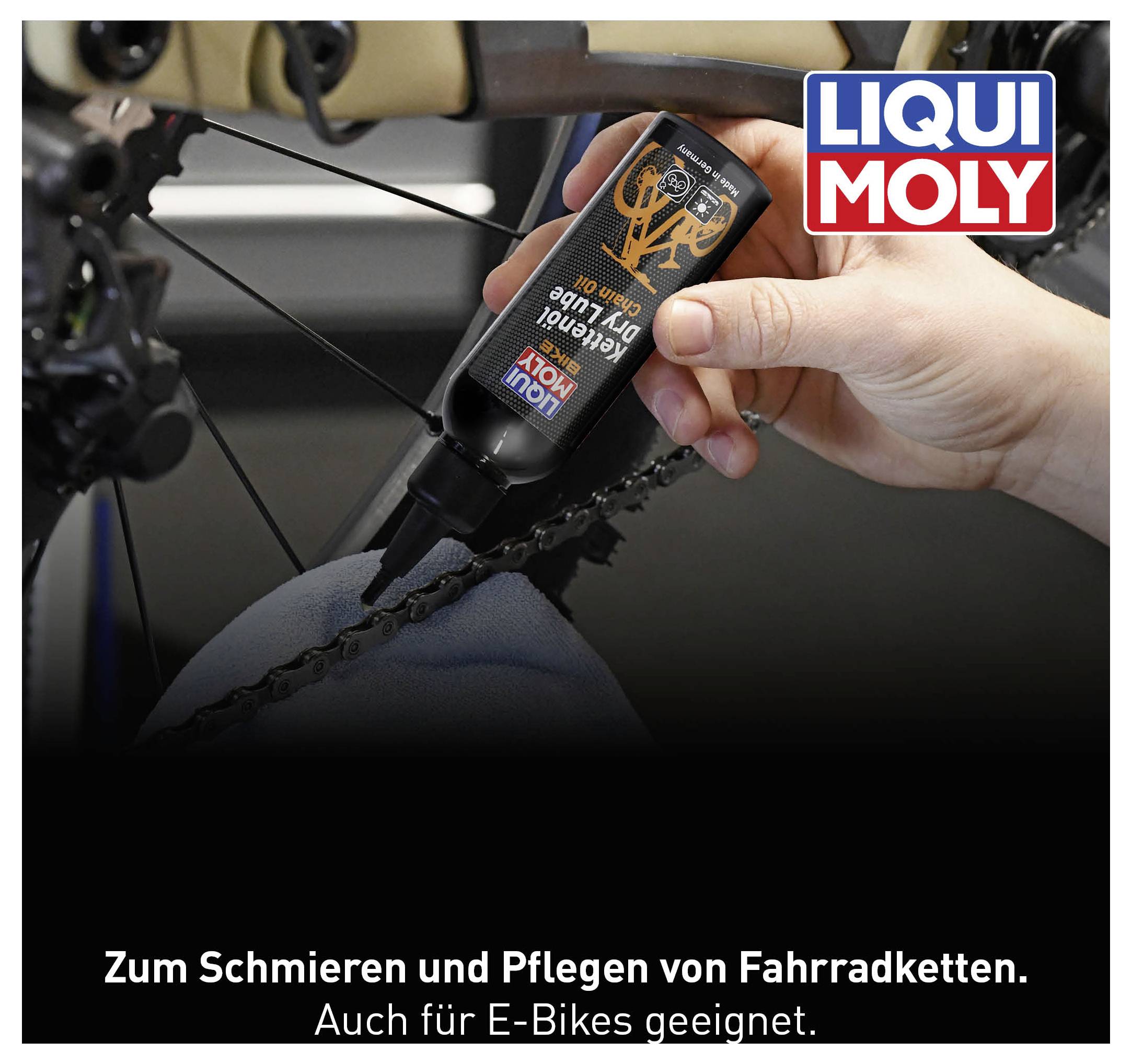 Eine Hand trägt Kettenöl auf eine Fahrradkette auf. Oben rechts ist das Logo 'LIQUI MOLY'. Text unten: 'Zum Schmieren und Pflegen von Fahrradketten.'
