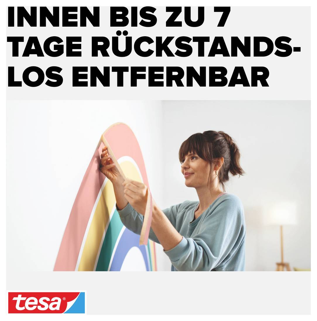 Eine Frau befestigt ein buntes Wandtattoo in Form eines Regenbogens an der Wand. Oben steht 'Innen bis zu 7 Tage rückstandslos entfernbar'.