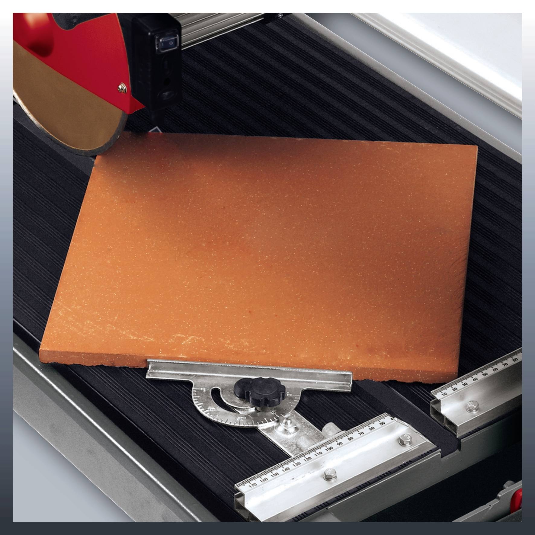 Eine Fliese wird mit einer Fliesenschneidemaschine geschnitten. Die rote Klinge ist teilweise sichtbar, und die Fliese liegt sicher auf dem Gerät.